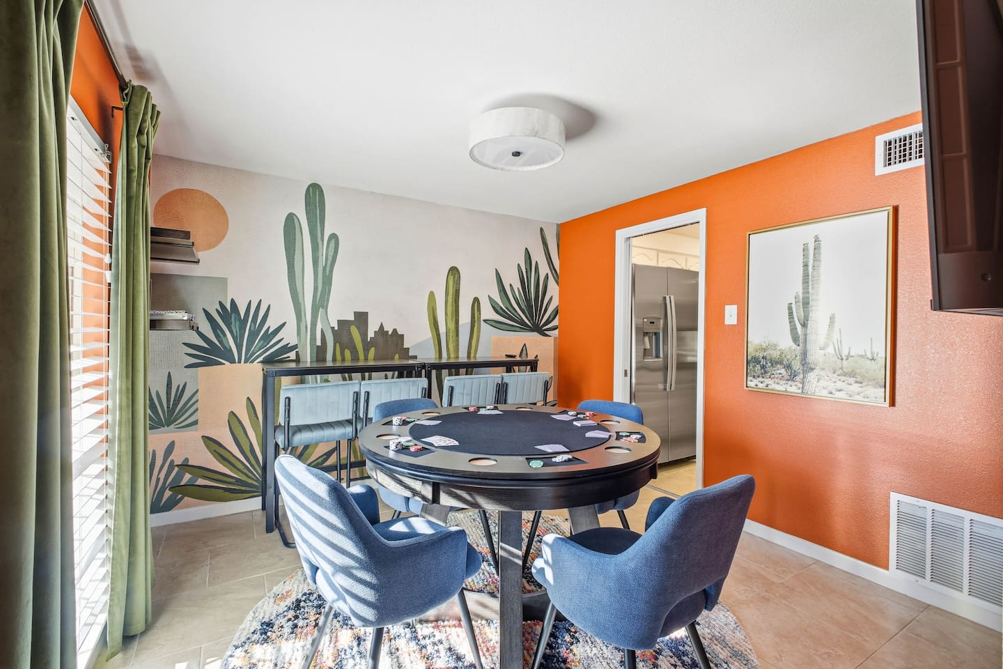 Downstairs game room with poker table and Roku TV; kitchen located just behind 