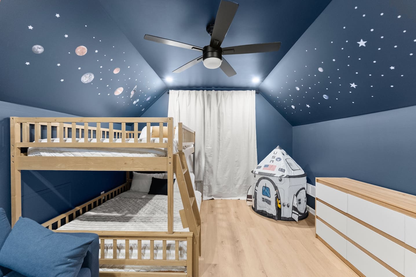 Glow-in-the-dark stars on the ceiling add a magical touch to this space-themed room.