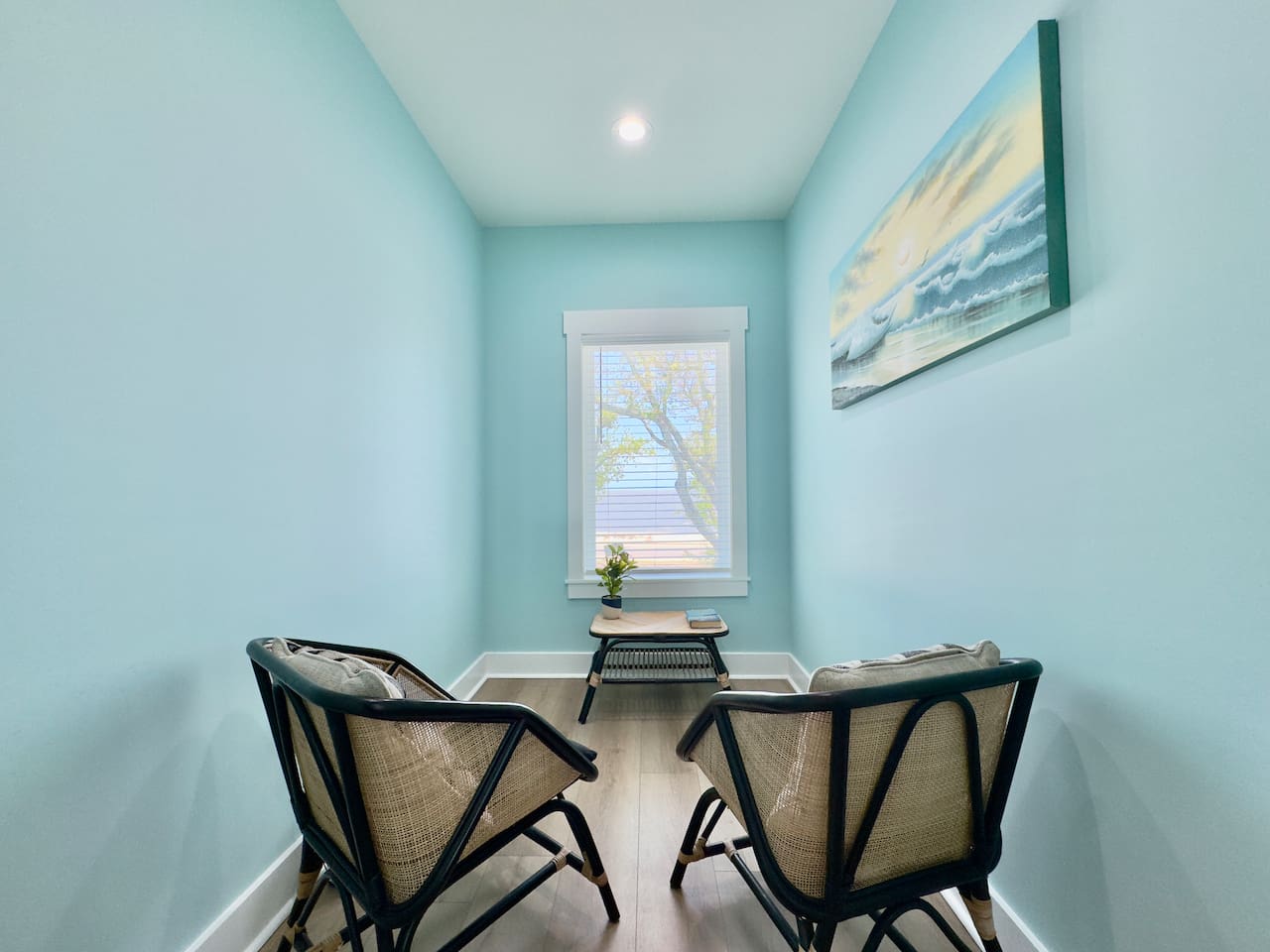 A cozy reading nook with chairs and a serene water view.