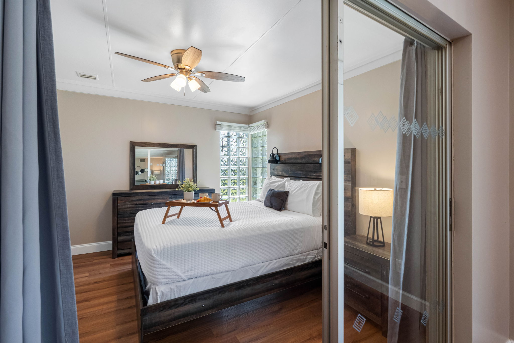 Large windows and glass accents allow plenty of natural light to flow in, giving the room a bright and refreshing feel.