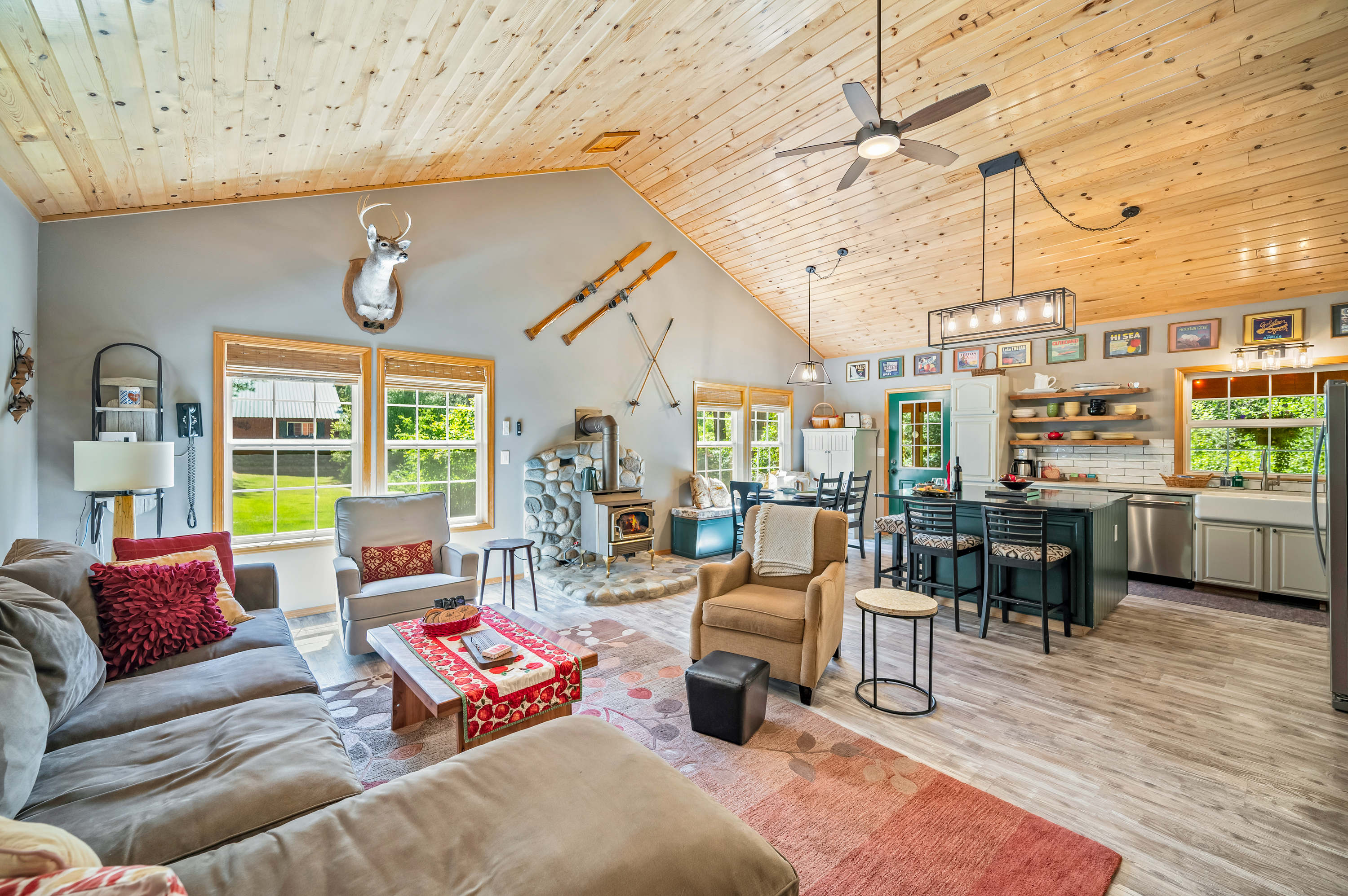 Open living area with large sectional, gas fireplace, dining room and kitchen with large island.