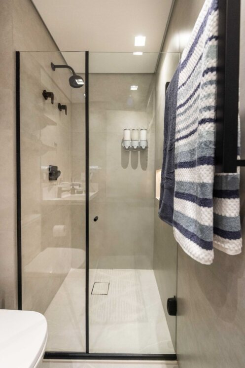 🚿 Box amplo com chuveiro de alta pressão e dispensers de xampu, condicionador e sabonete líquido.