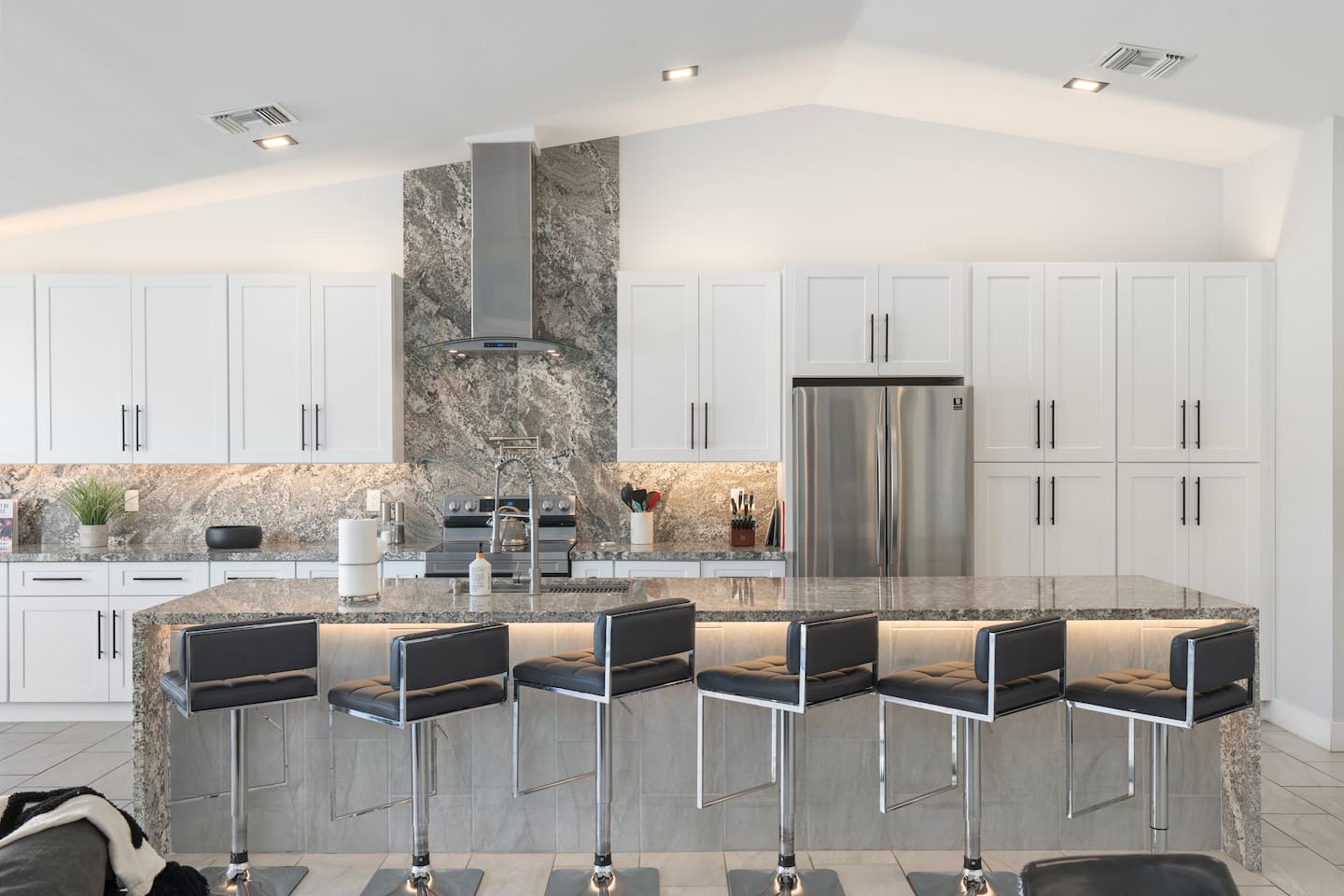 Sleek chef’s kitchen with ample seating.

