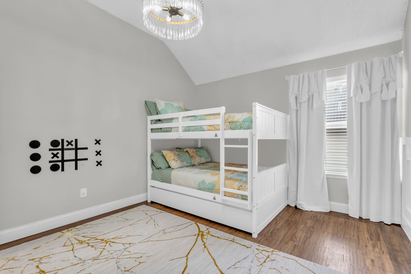Spacious bunk bedroom featuring queen-over-queen bunk beds, room-darkening blinds, ceiling fan, fresh bed linens, and a comfortable layout for group stays.