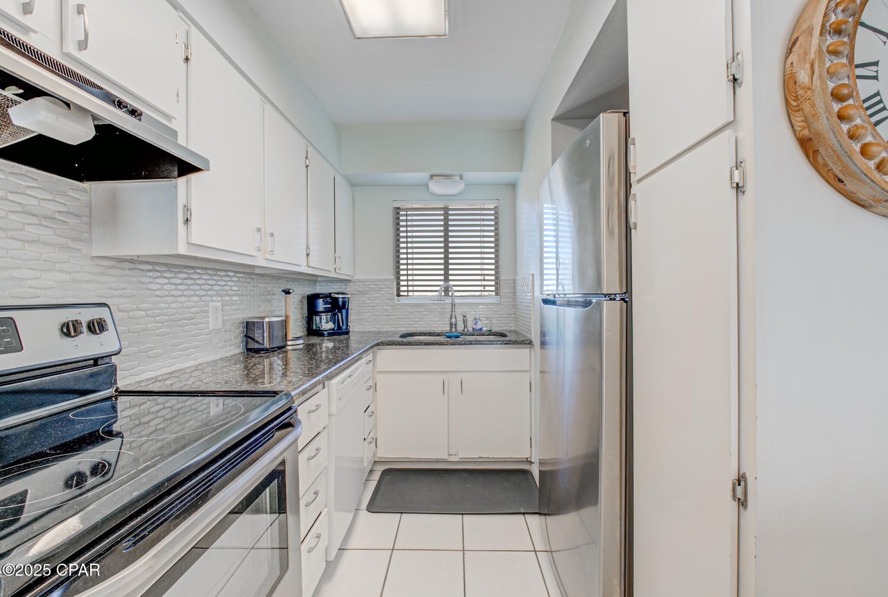 Kitchen with full refrigerator, dishwasher, microwave, coffee maker.