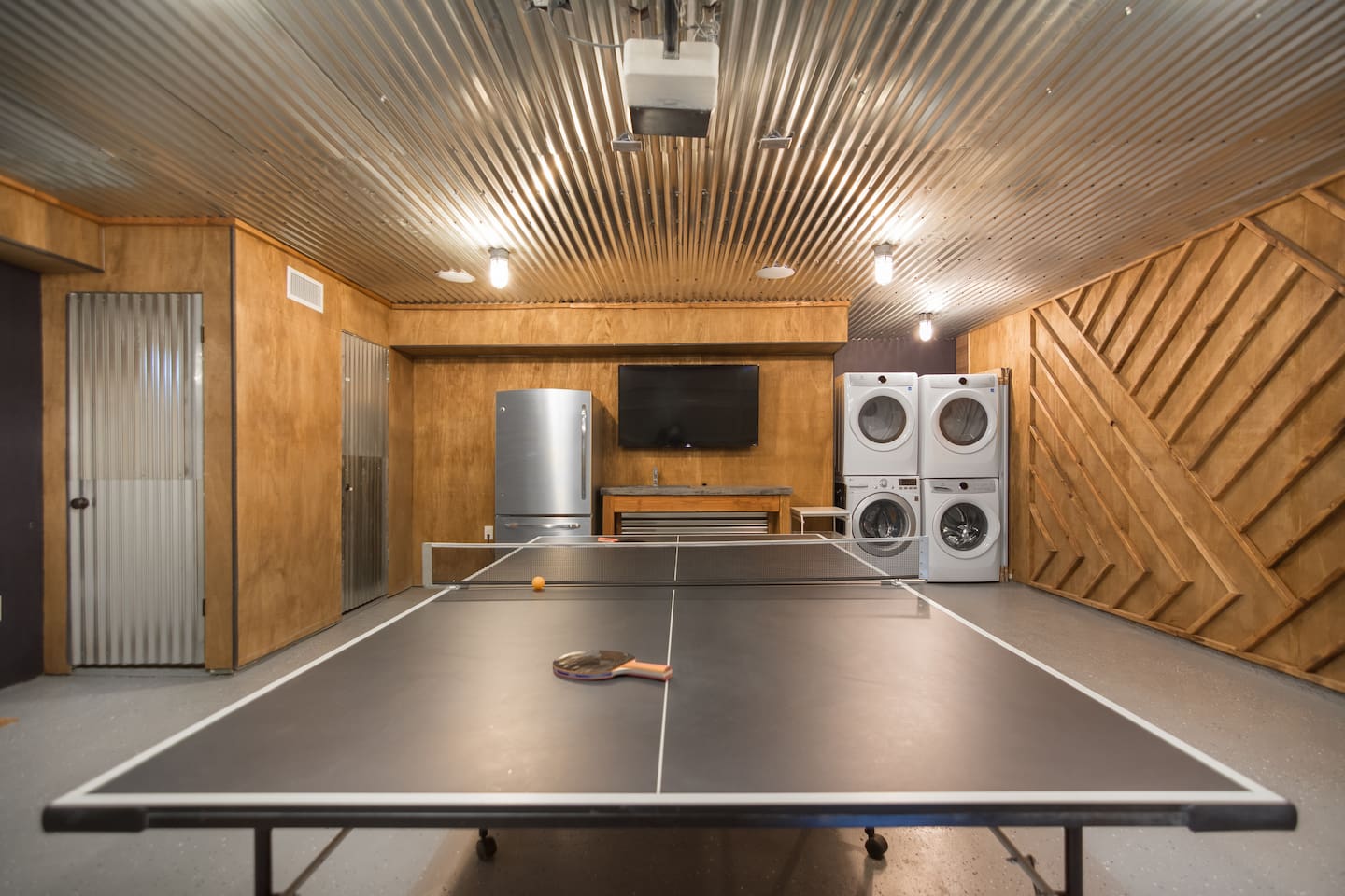 Game room with ping pong, tv, bar, and large beverage refrigerator