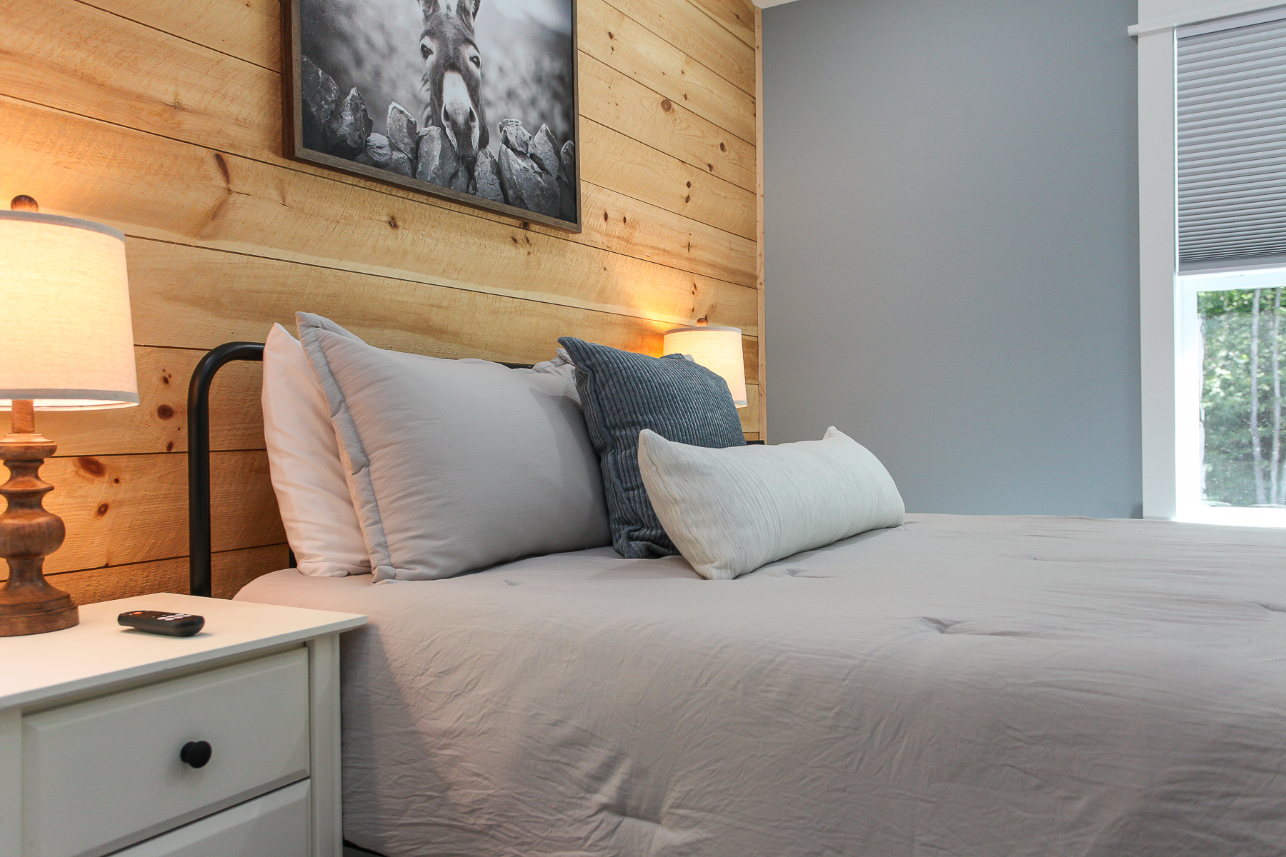 Soft neutral bedding and bedside lighting create a cozy, welcoming retreat in this upstairs queen bedroom at Robbin’s Nest on Snowbird Creek.