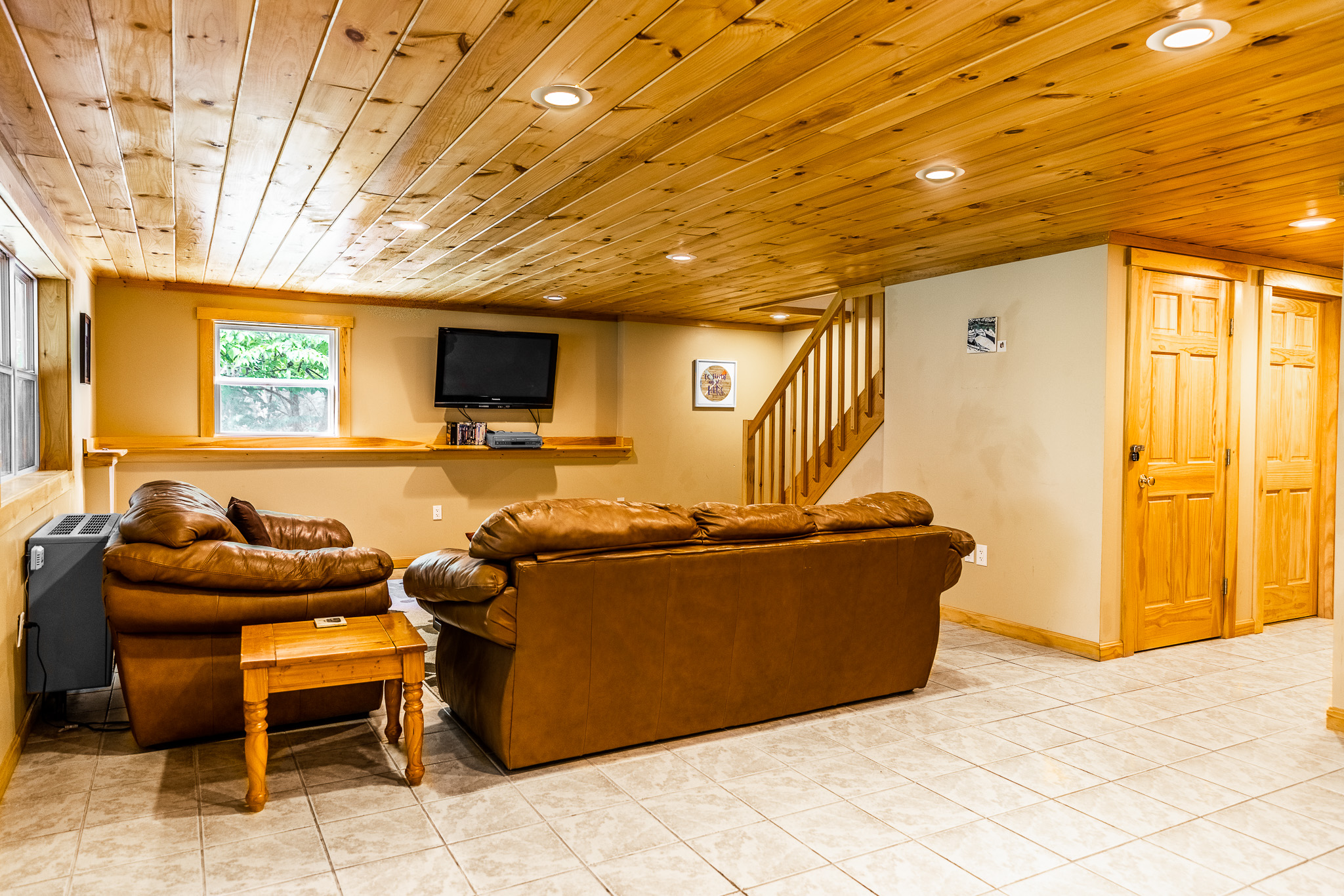 Downstairs entertainment area with comfortable leather couches, Roku TV, DVD player with some movies, drink refrigerator, access to covered and screened outdoor kitchen area.