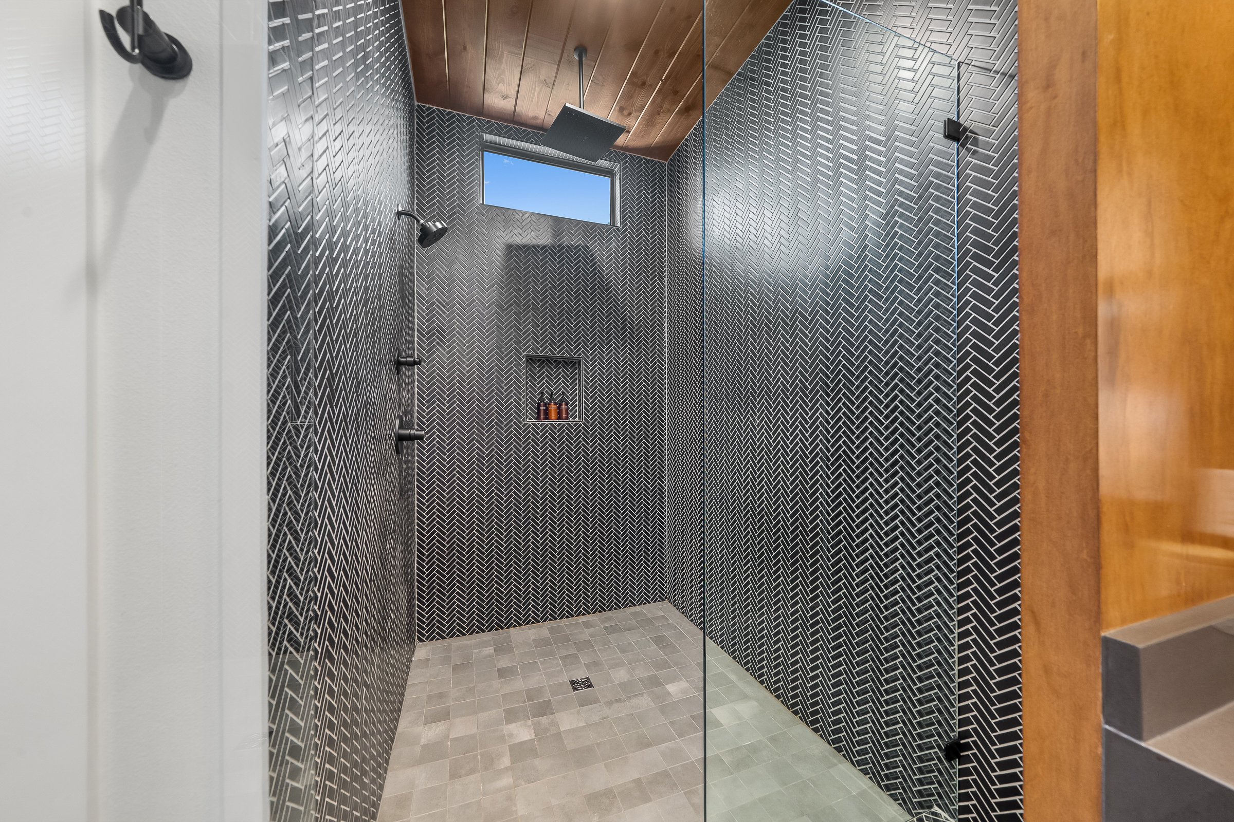 Semi-private bathroom for those staying in the Bunk room. This bathroom features modern teak finishes, stunning modern design, and an oversized rain shower with dual shower heads. 