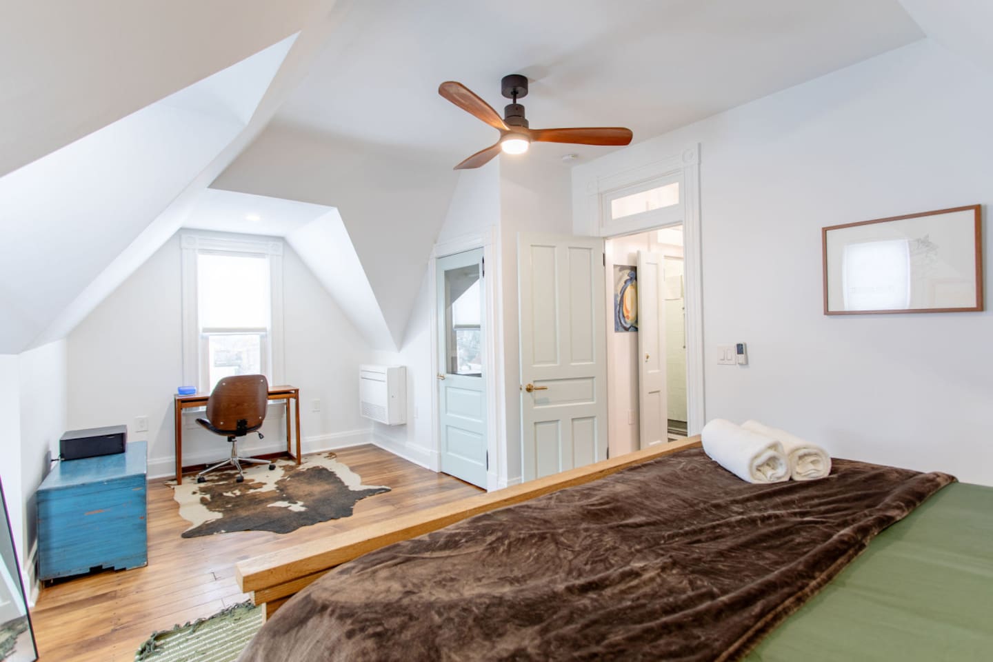A spacious bedroom with ample room, featuring a dedicated workspace with a stylish desk and comfortable chair, offering a perfect balance of relaxation and productivity.