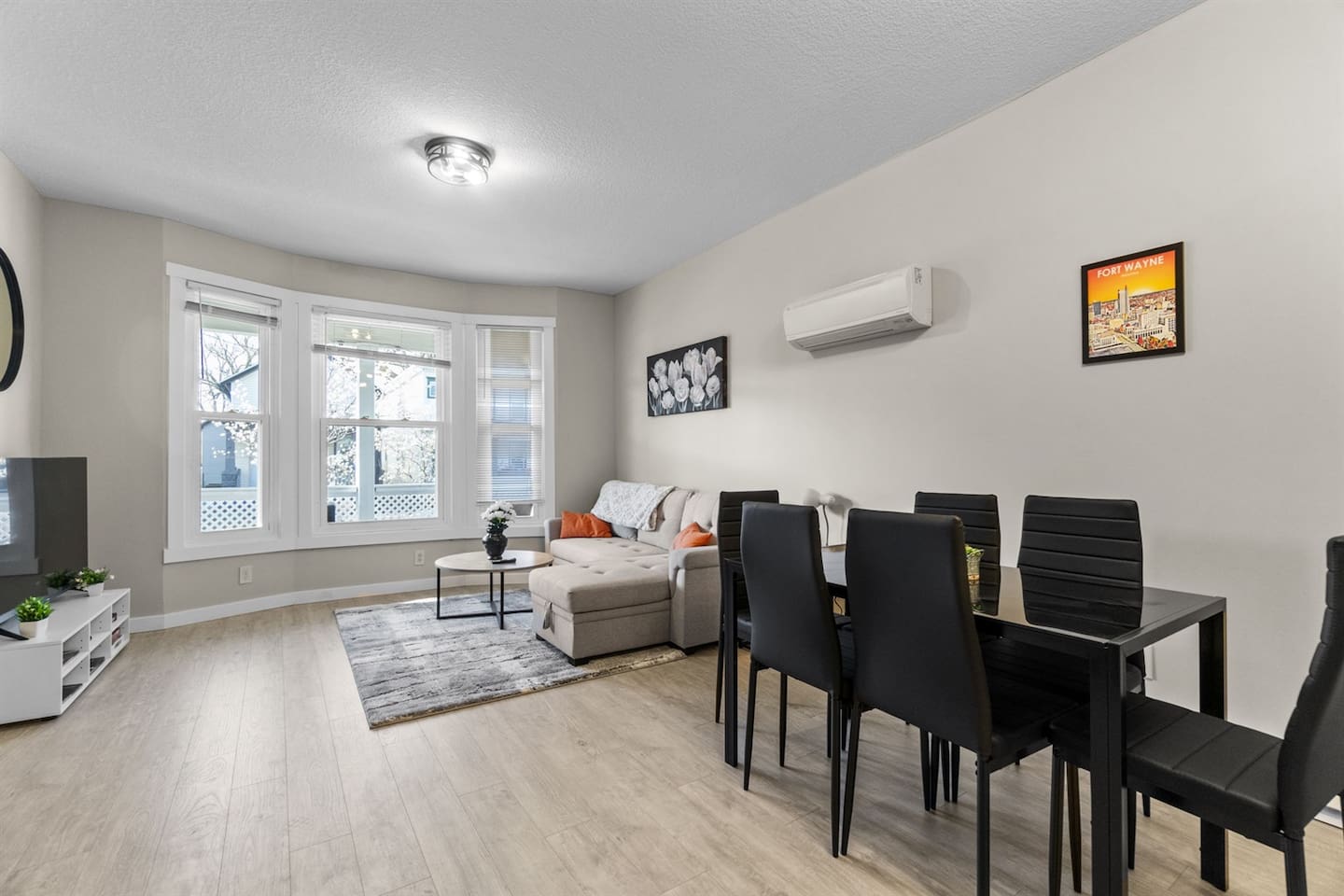 Bright and airy living and dining room filled with abundant natural light from large windows.
