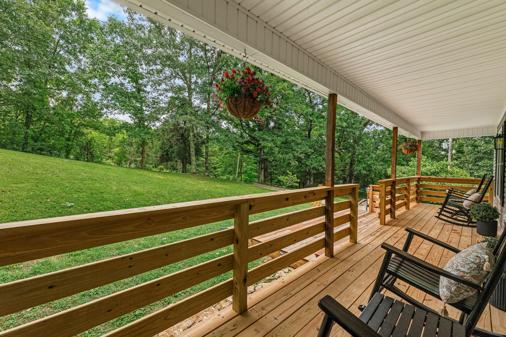 Rock, relax, repeat. This peaceful porch is your front-row seat to nature’s slow show. 🌳🪑✨