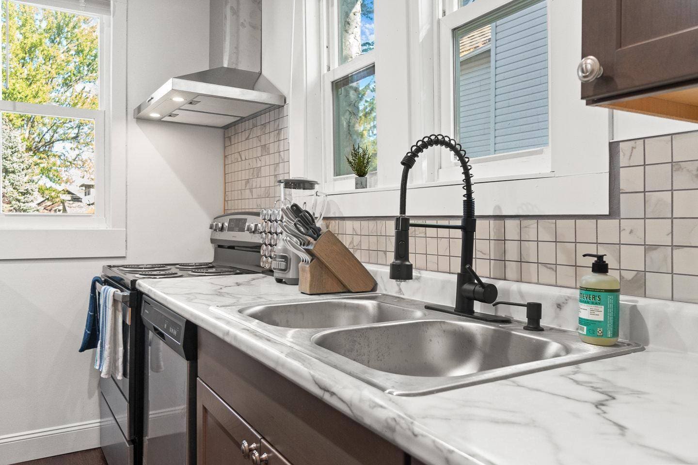 Fully equipped kitchen featuring a clean, organized countertop stocked with essentials. Adjacent to the counter, you'll find a sleek stove and oven, perfect for preparing meals with ease and style.