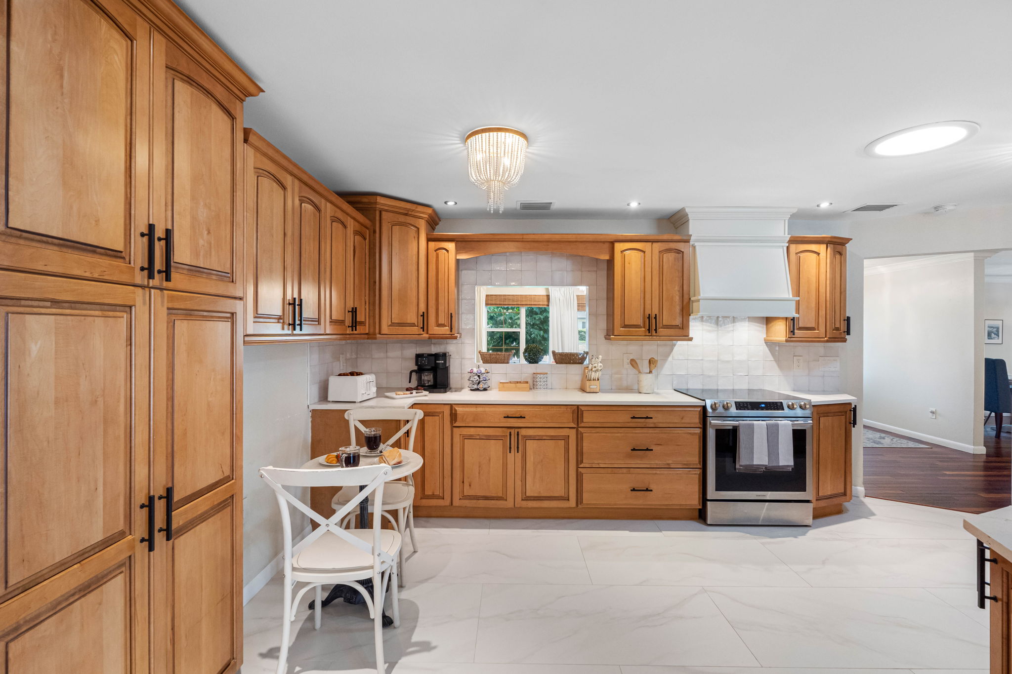 A window over the sink fills the kitchen with natural light, enhancing its airy and welcoming feel.