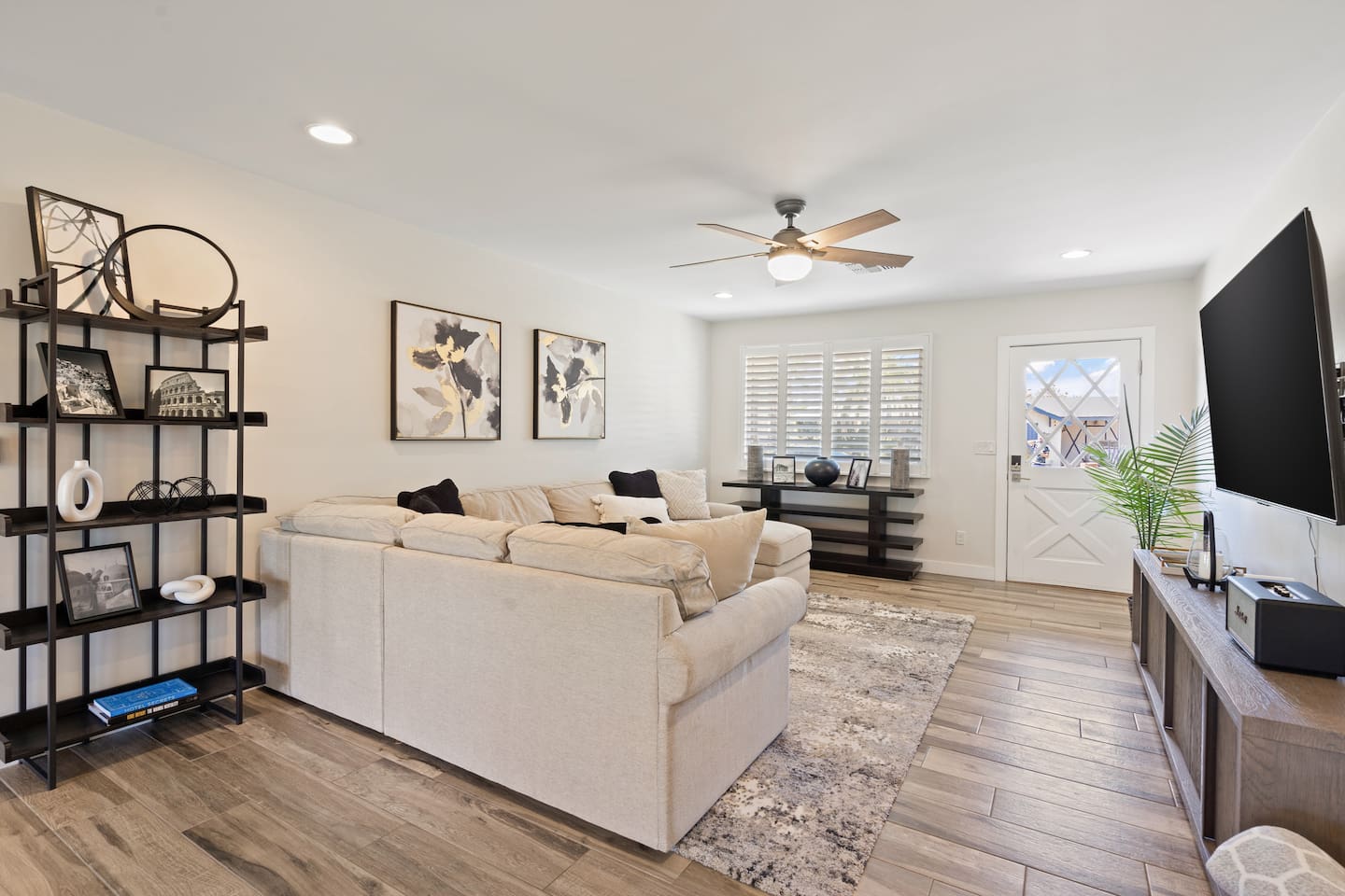 Open living room with large sectional seating, ceiling fan, perfect for gathering!