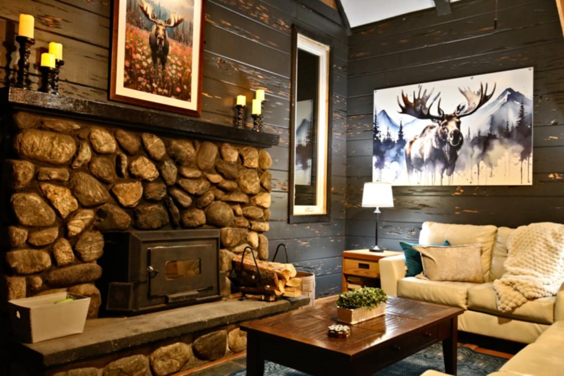 Cozy up by your stone fireplace with a crackling fire, 65" Roku TV, plush throws, and moose art that brings the mountains inside—your perfect spot to unwind after a day of adventure.