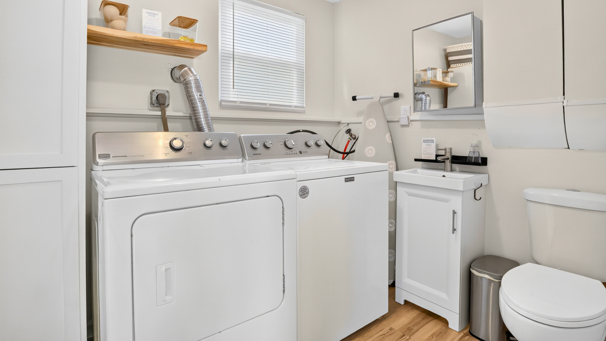 Laundry room with a convenient half bath, ironing essentials, and starter laundry supplies.