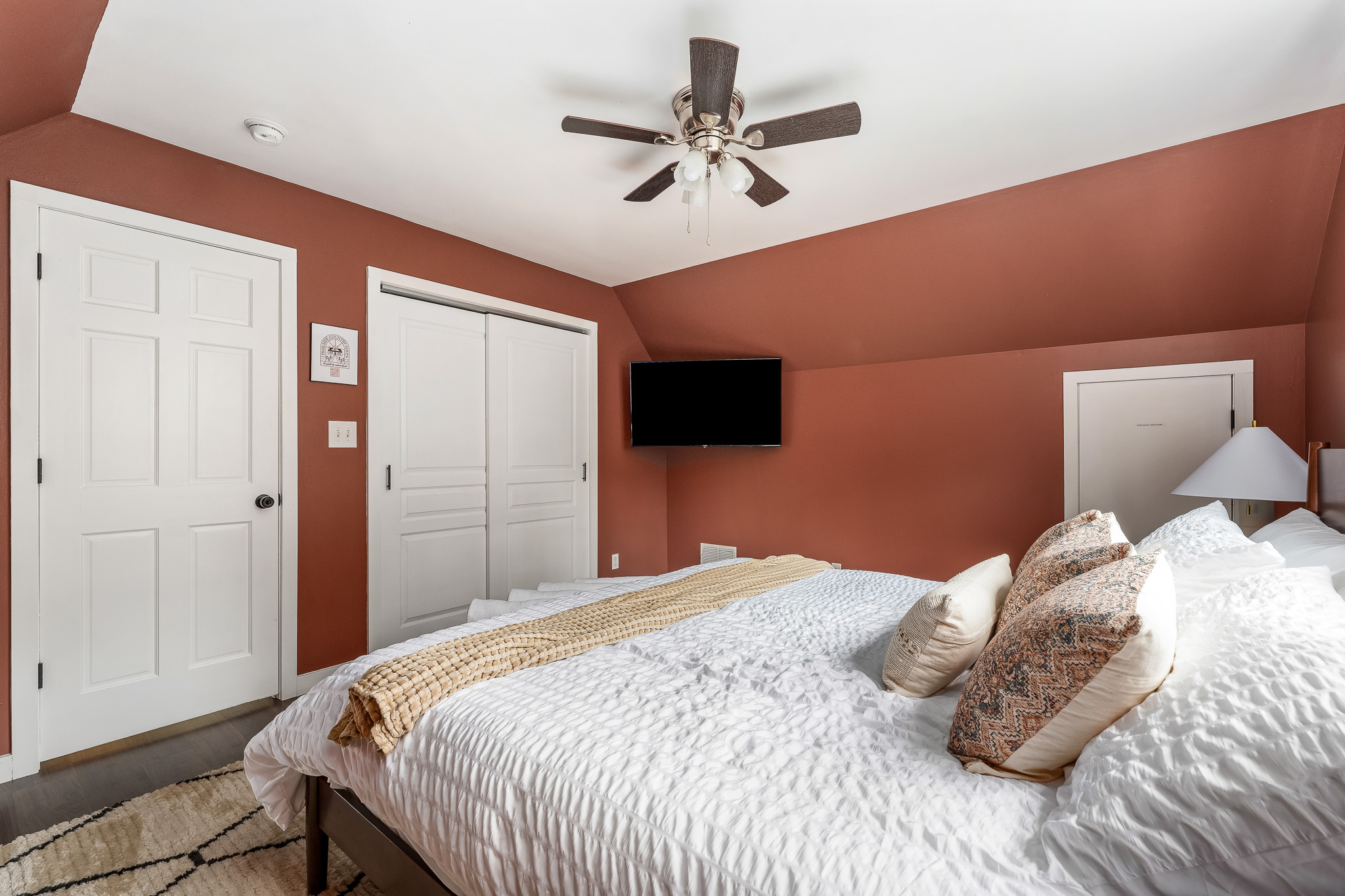 Comfort meets character This upstairs king room blends bold walls with soft layers, smart TV access, and ample storage—your cozy hideaway with a touch of style. 🛏️🎨📺