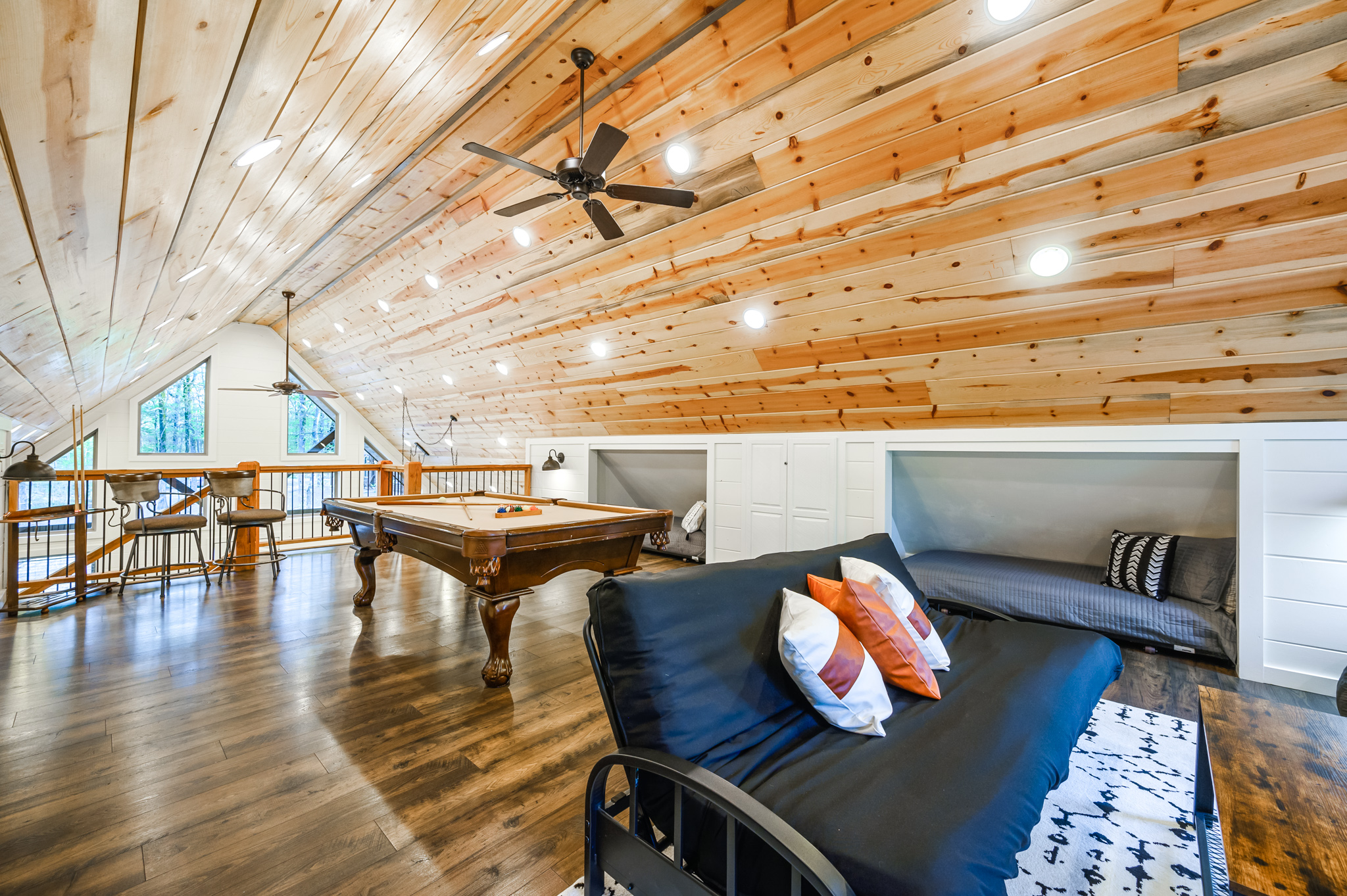 Boots + Beats | Loft with pool table and sectional couch. The older futon is no longer a bed; the loft’s four roll-out twin beds are the sleeping spaces.