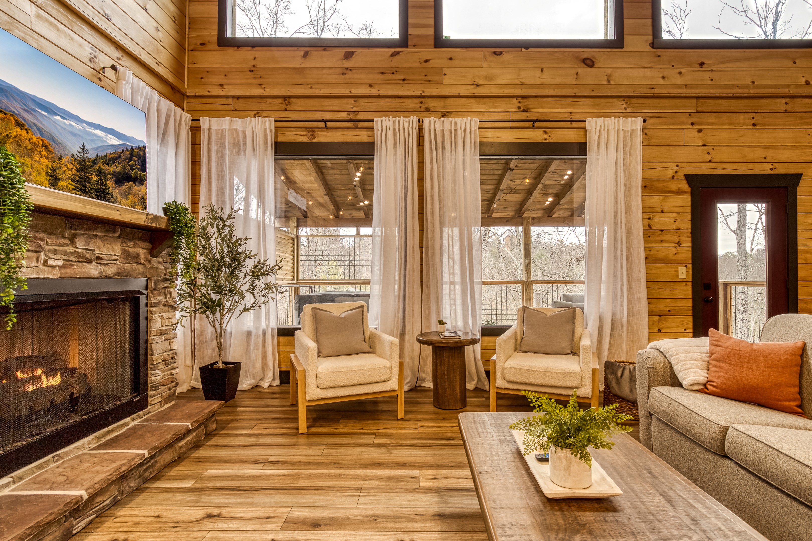 Cozy up in the living room where soft lighting, warm wood, and a crackling fire make every night feel special