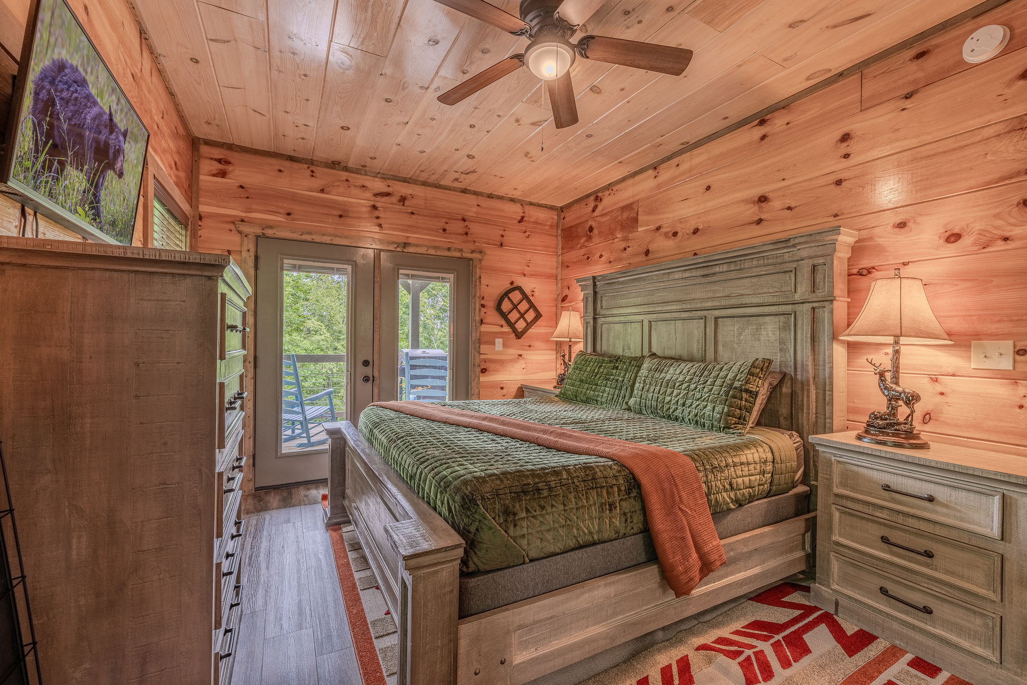 The Cartographer’s Suite offers a restful main-floor retreat with warm wood, layered bedding, a Smart TV, and private en-suite access.