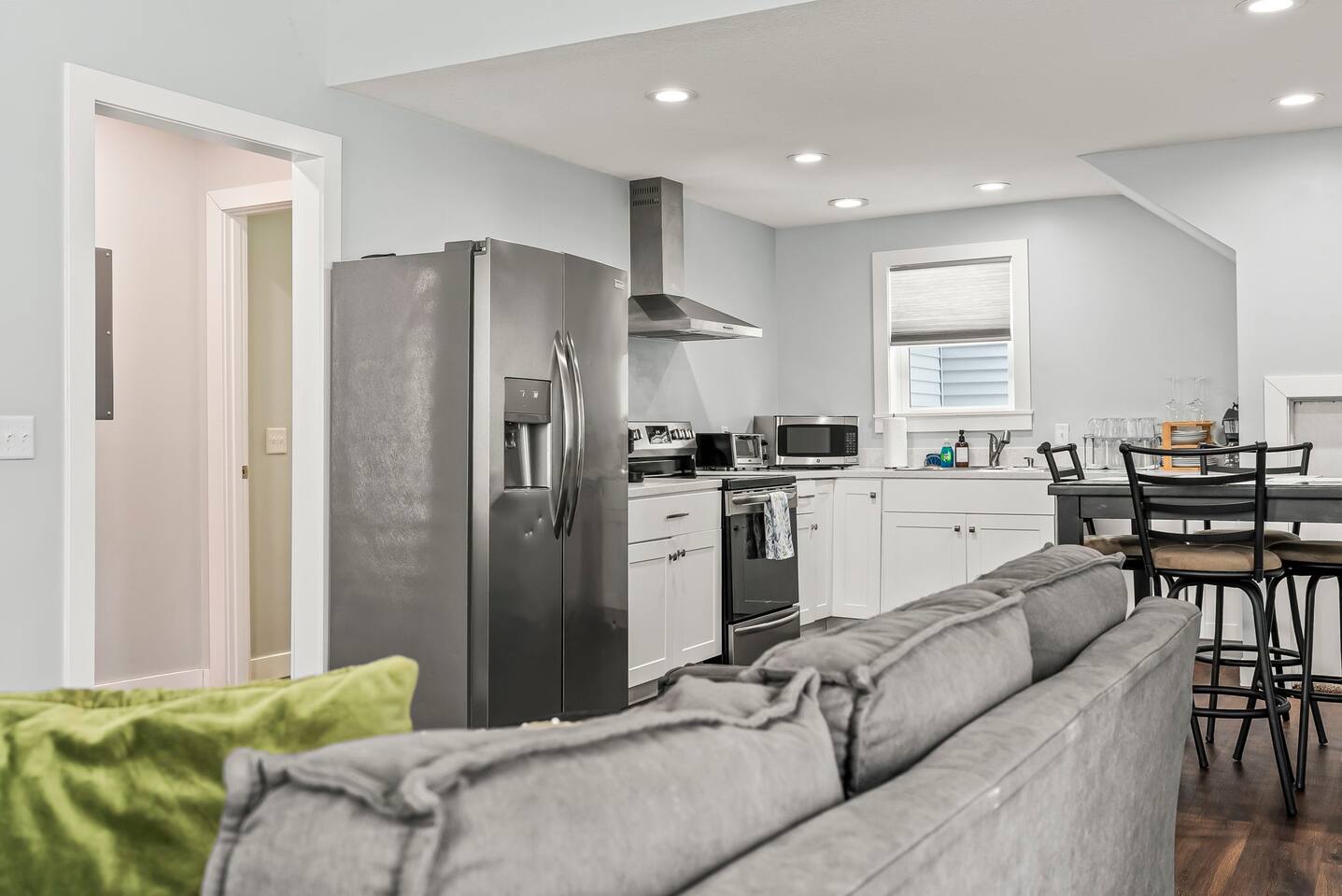 Open kitchen view from the living room showcasing stainless steel appliances, modern cabinetry, and an easy, open-concept layout.