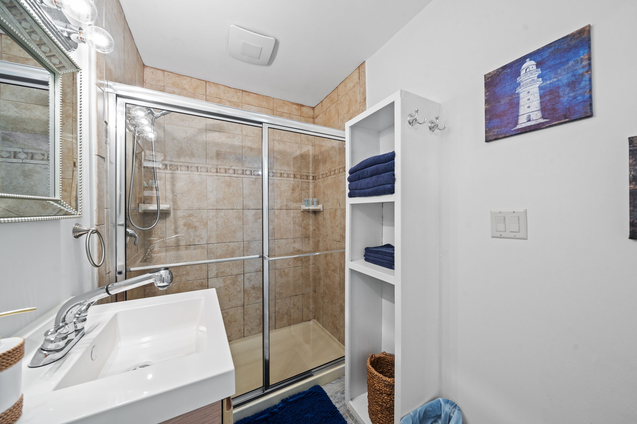 Walk-in shower with built-in shelving and fresh linens