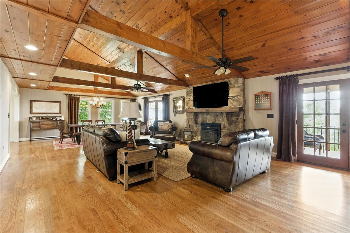 The large, spacious living room features vaulted ceilings, plenty of comfortable seating with couches and chairs, and a smart TV for your entertainment