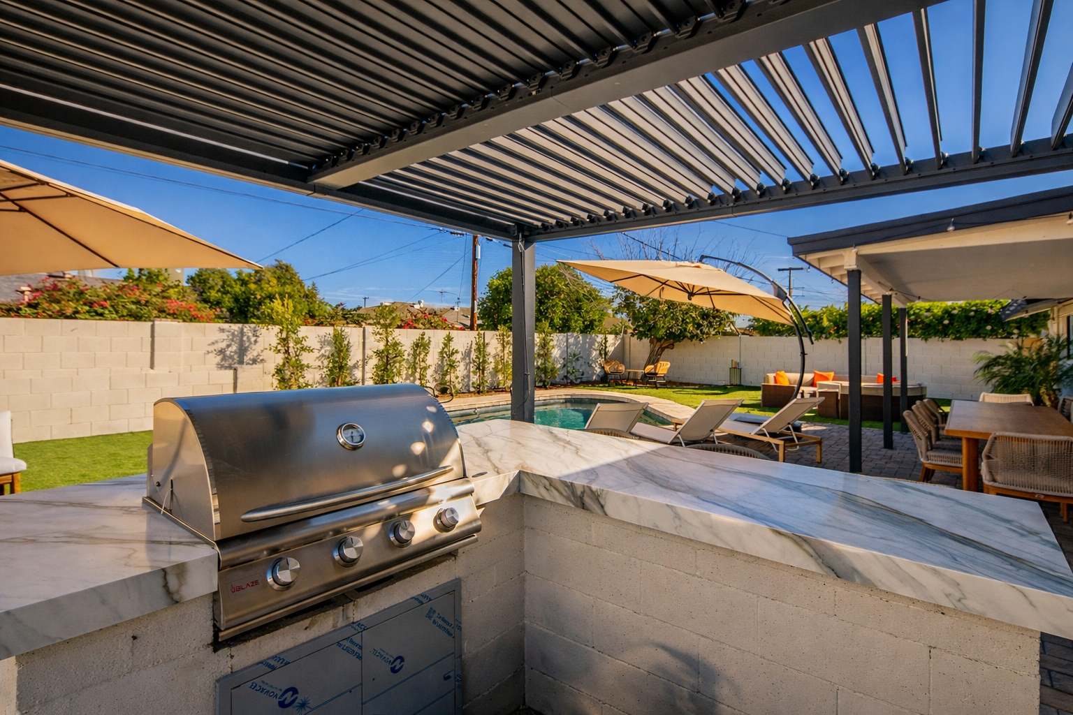 Outdoor kitchen with built-in grill, prep space, and shaded pergola — perfect for BBQs, entertaining, and outdoor dining in Scottsdale.
