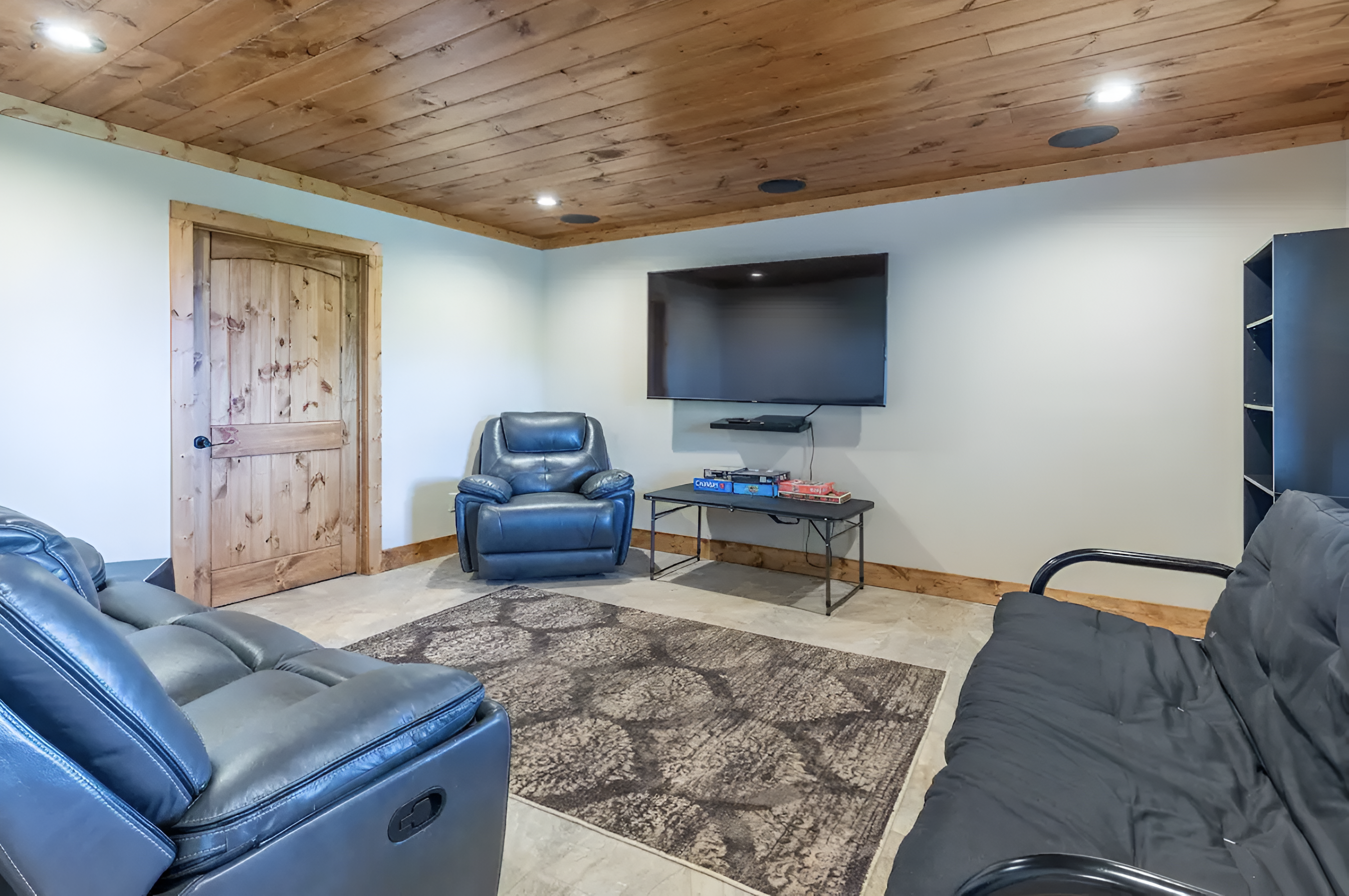 The lower level game room extends into the media room, which features a large TV, DVD collection and surround sound. The futon sofa features a full size lay-down format.