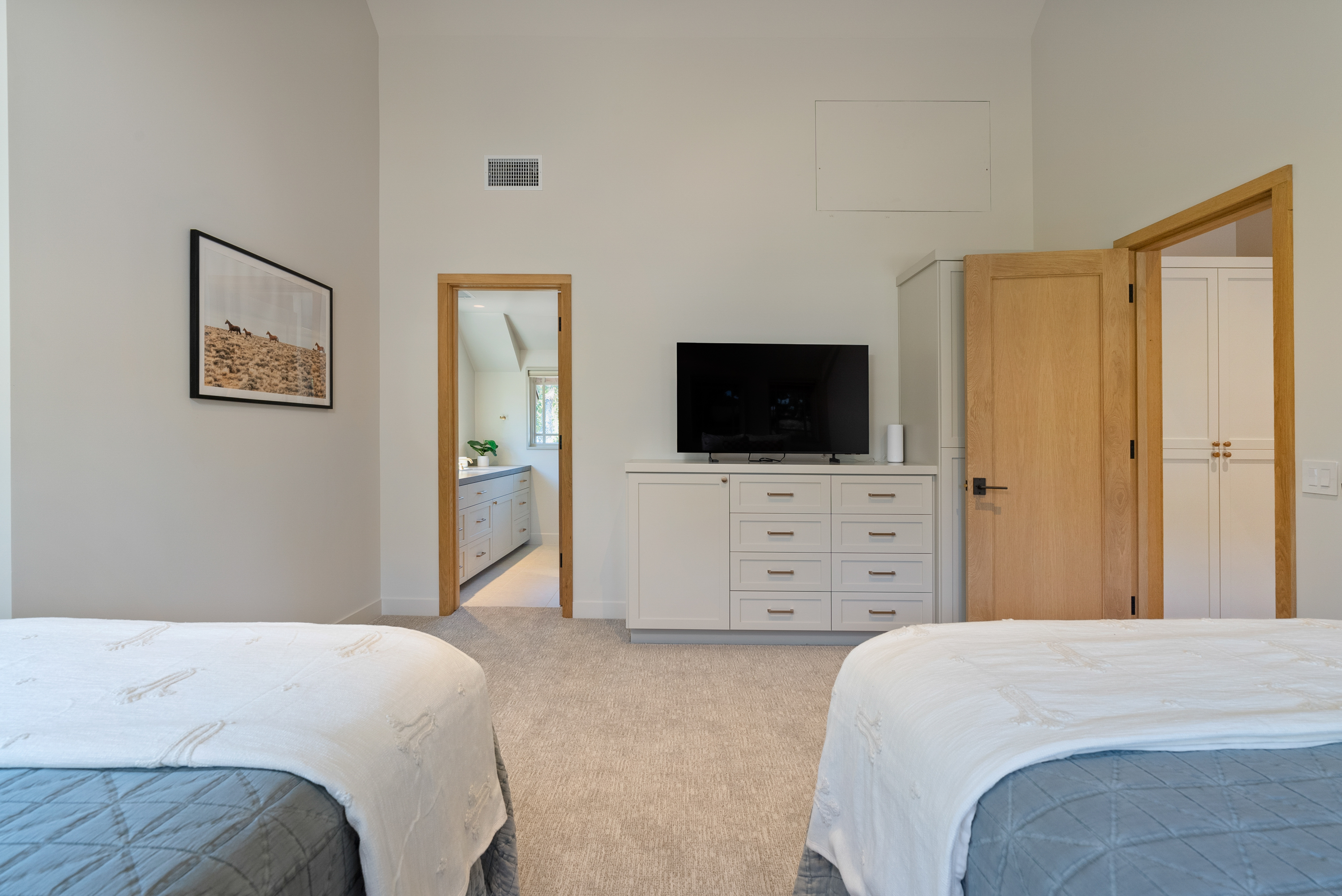 Family-friendly room featuring dual queen beds, dresser, and TV space