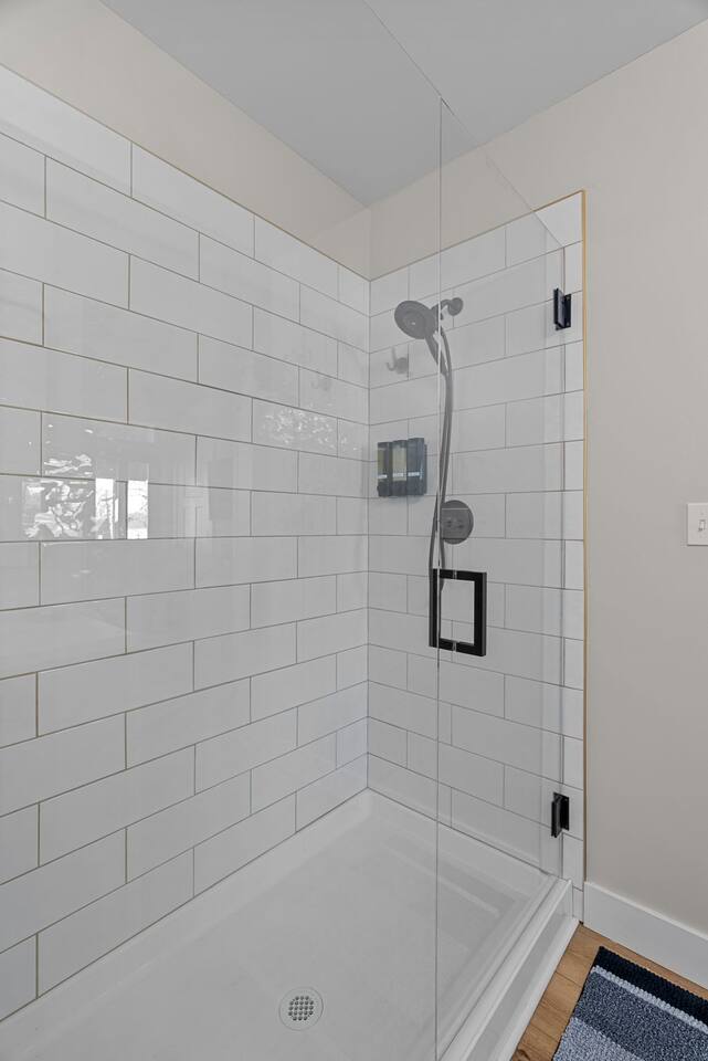 Spacious shower stocked with Shower gel, Shampoo, and Conditioner.