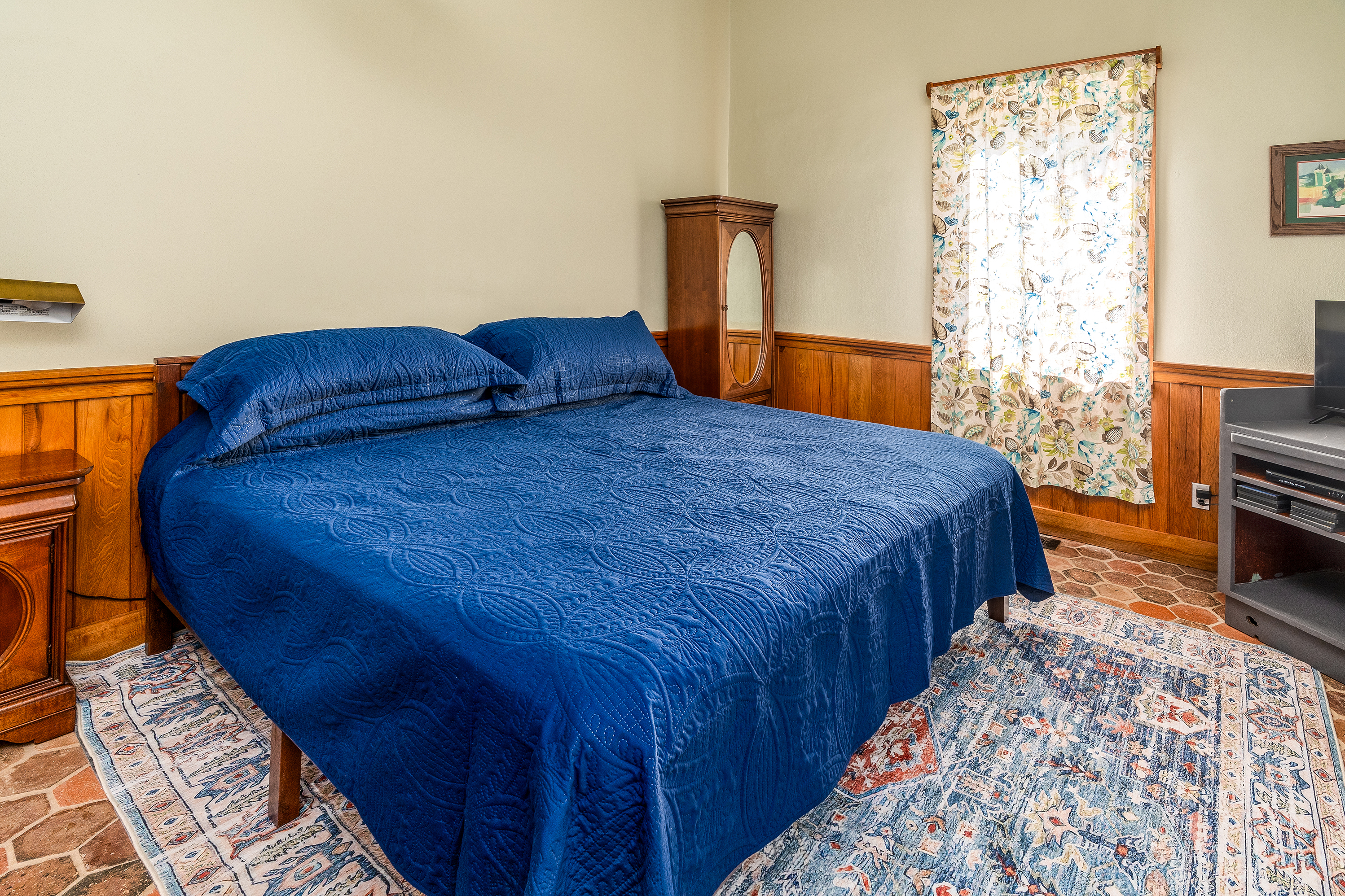 Spacious main bedroom with a comfortable king bed, smart TV, and ample natural light.