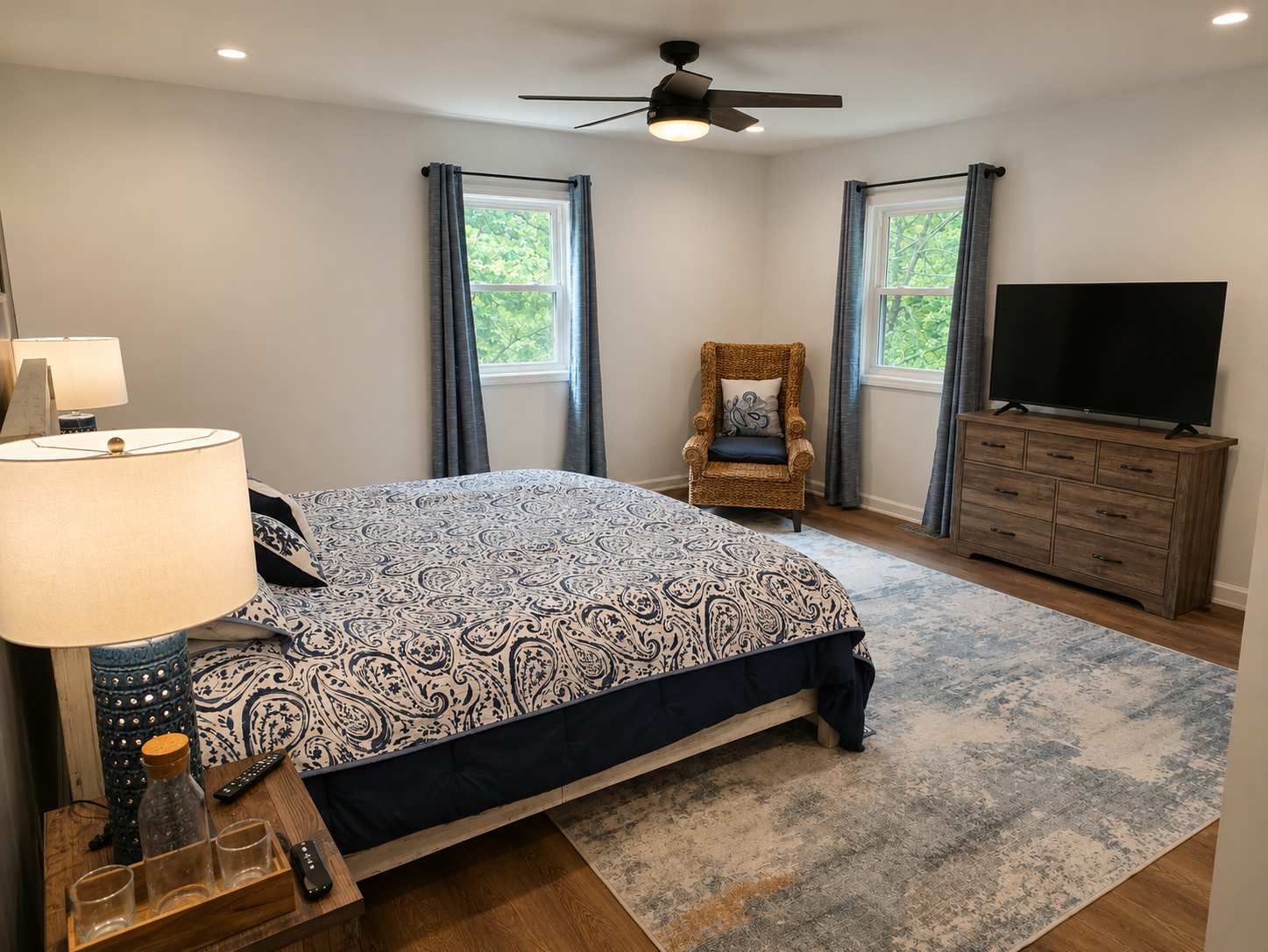 Main-floor primary bedroom with a king bed, cozy lighting and a calm, comfortable layout.