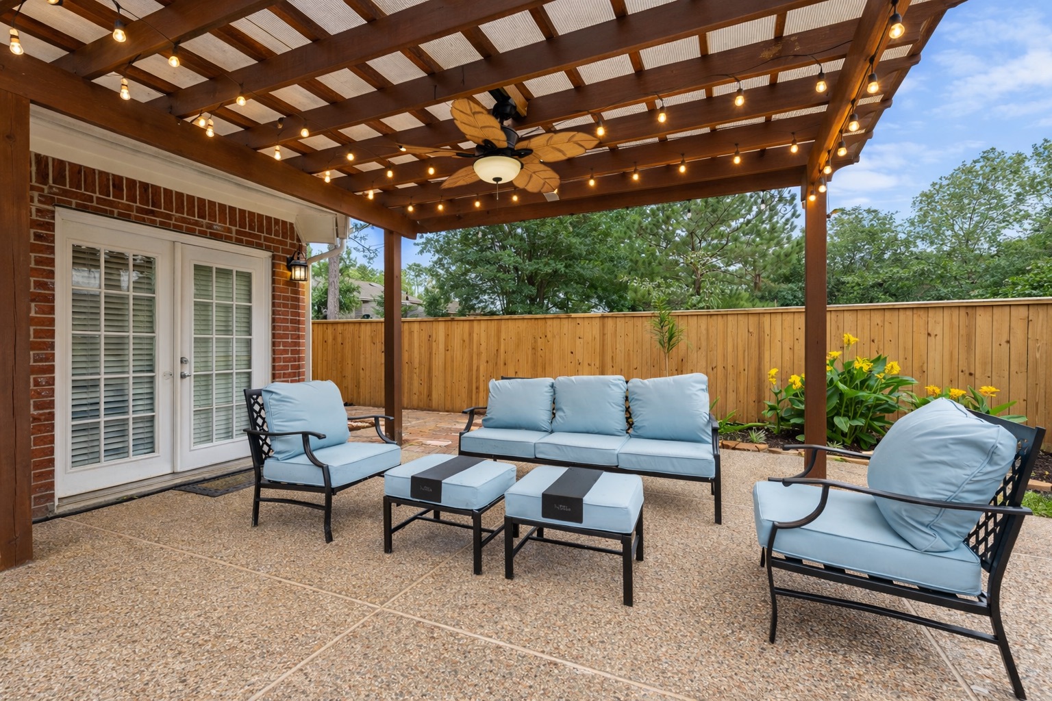 Relax under the covered pergola with cozy cushioned seating and ambient café lights — the perfect shaded spot for morning coffee or evening wine.