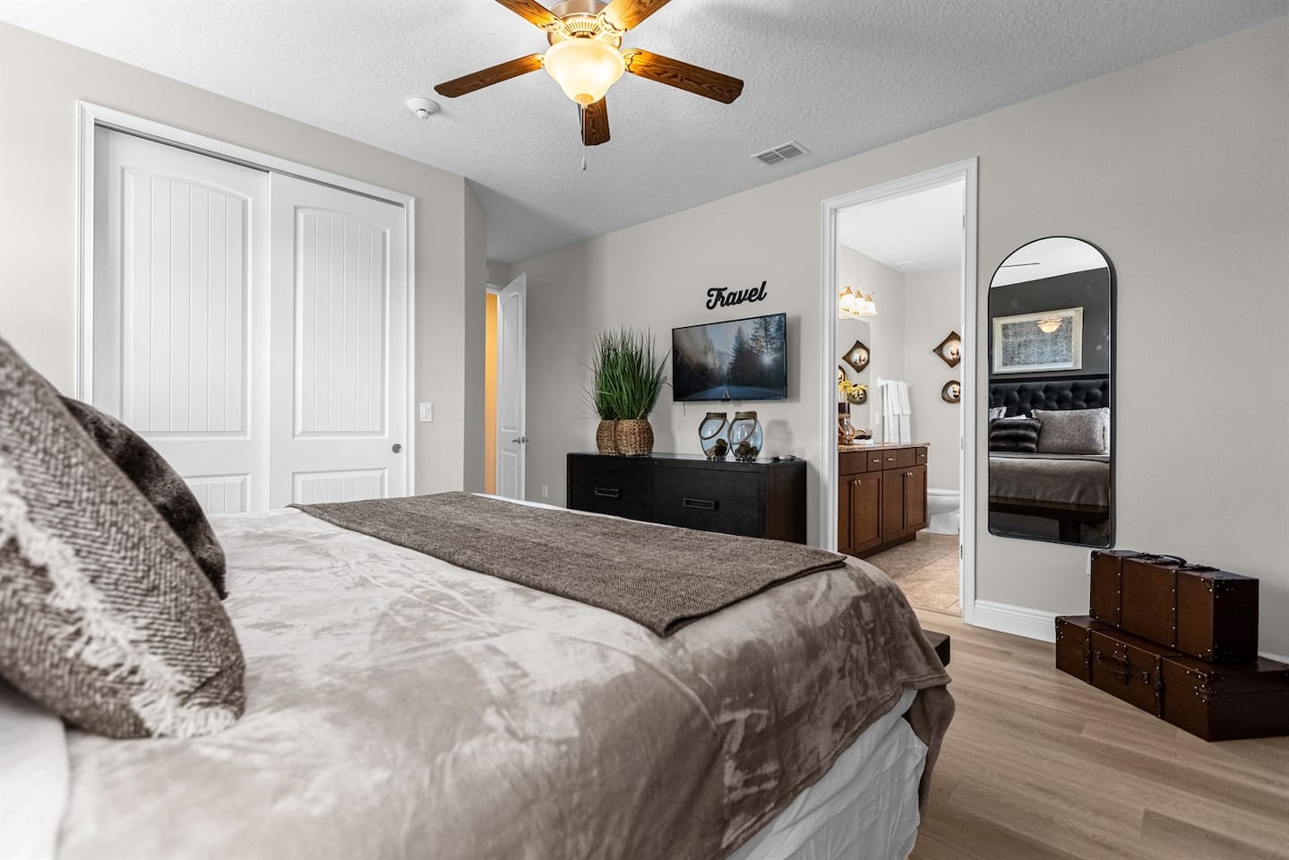 Travel-themed bedroom featuring a king-size bed with luxurious sheets and pillows, decorated with travel-inspired accents to inspire wanderlust and create a cozy retreat for adventurers.