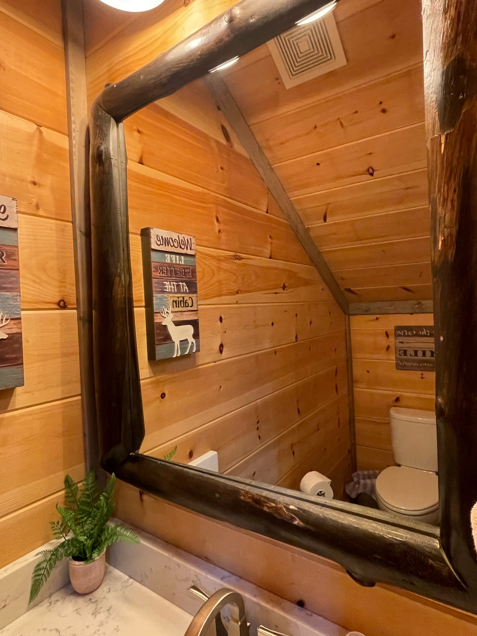 Cozy half bath under the stairwell is a well thought out feature of this cabin and limits the traffic to the beautiful master bedrooms!