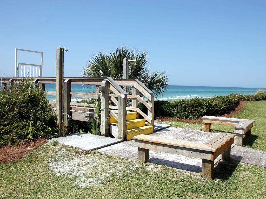 The boardwalk to the beach is next to the pool. with a shower for sandy feet.