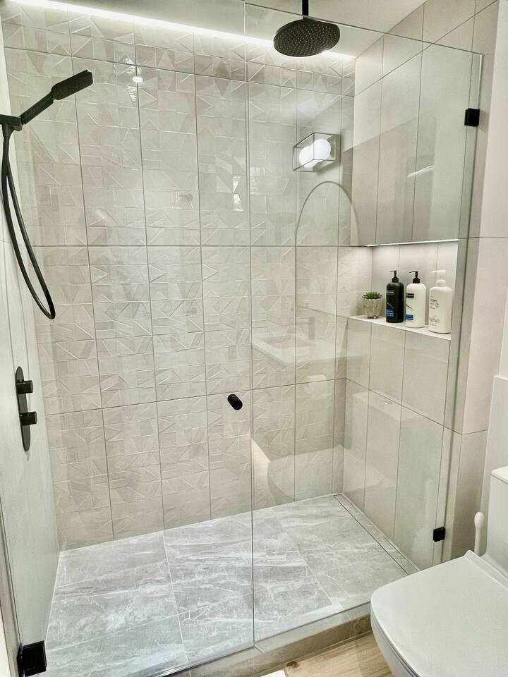 Large walk-in shower w/ rain can shower head and separate wand. Heated floors keeps it cozy.