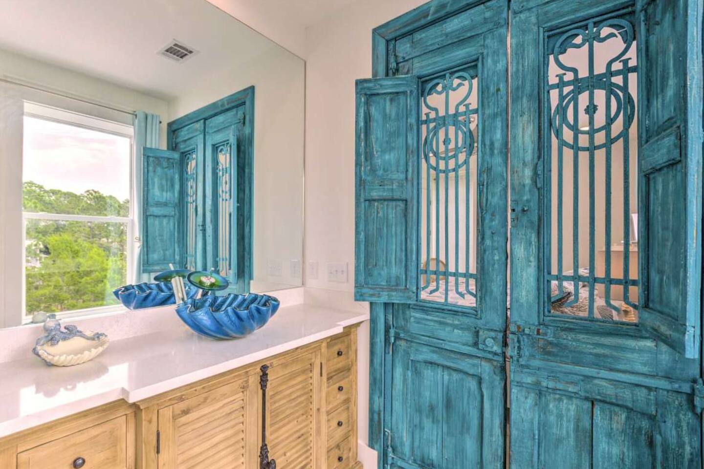 Indulge in the luxurious master bath featuring a 200-year-old antique speakeasy door imported from France. Admire the authentic steel grid and hand-carved wood panel—a true piece of history for your Blue Mountain Beach getaway