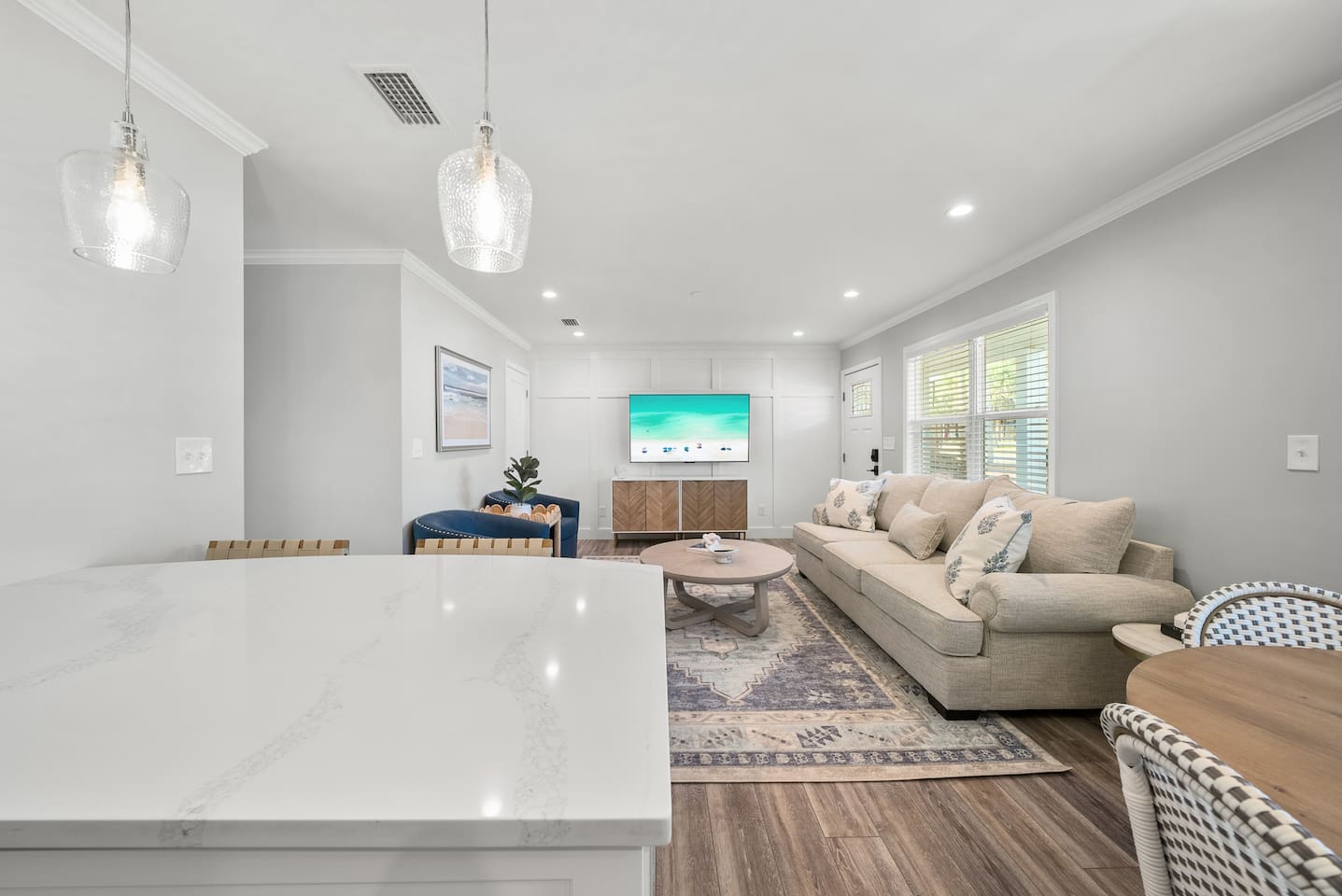 Living room of Unit A. Featuring a sleeper sofa, open concept to the kitchen and a smart TV.