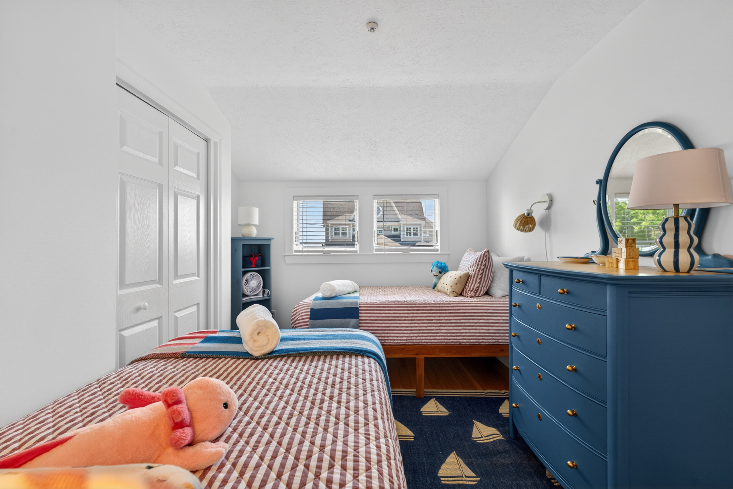 Cheerful twin bedroom with two beds and cozy coastal touches, ideal for kids or extra guests.