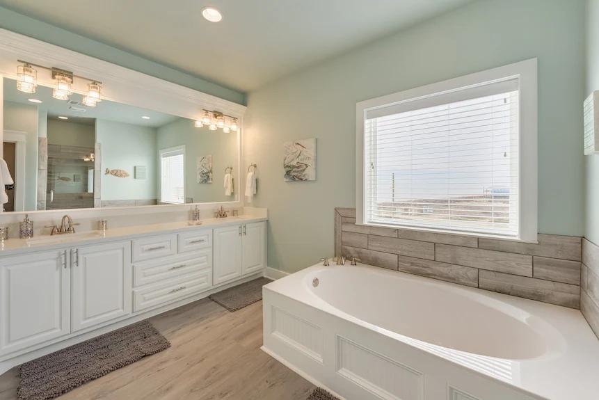 Breezy Point Bathroom 3: Spacious ensuite featuring a soaking tub, walk-in shower, and double vanity with ample storage directly connected to Bedroom 4.
