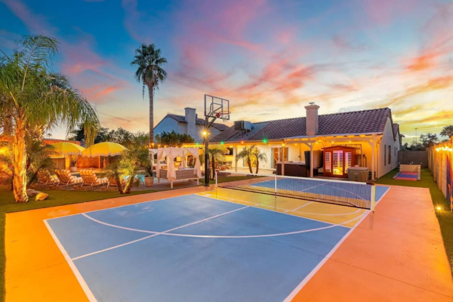 The private basketball court glows under a vivid desert sunset — game time never looked so good.