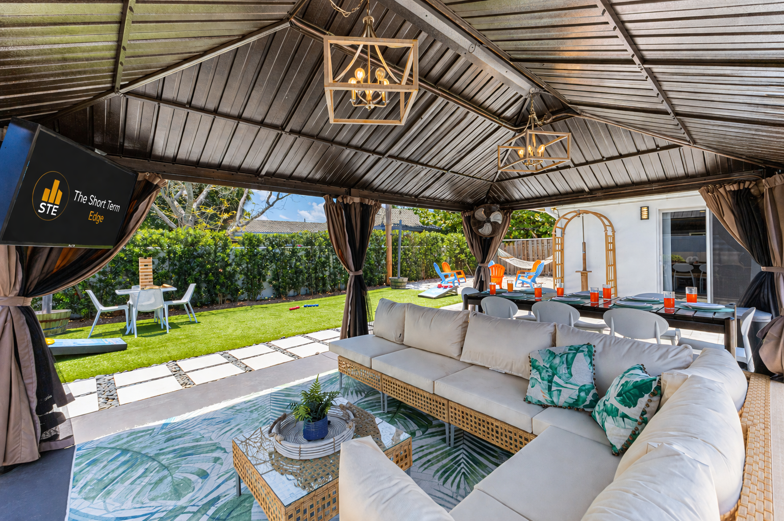 Outdoor Smart TV, comfy couch, and industrial fan — backyard game nights made easy!