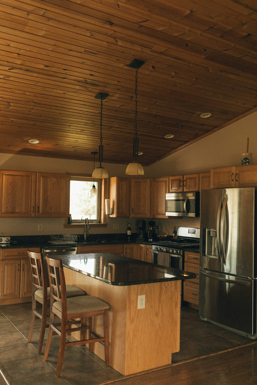 Kitchen with island and 2 barstools