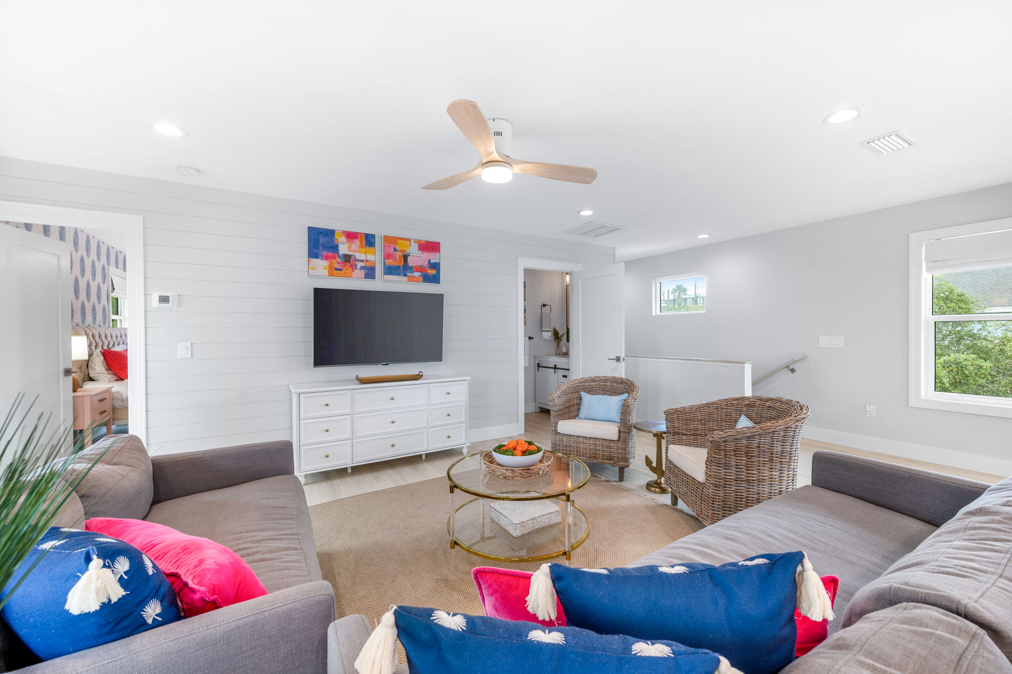 Here’s the cozy living room, perfect for winding down with friends and family after a day at the beach. The stairs to the downstairs are on the right, and the door to the upstairs master is on the left—ideal for relaxing and catching a movie together!