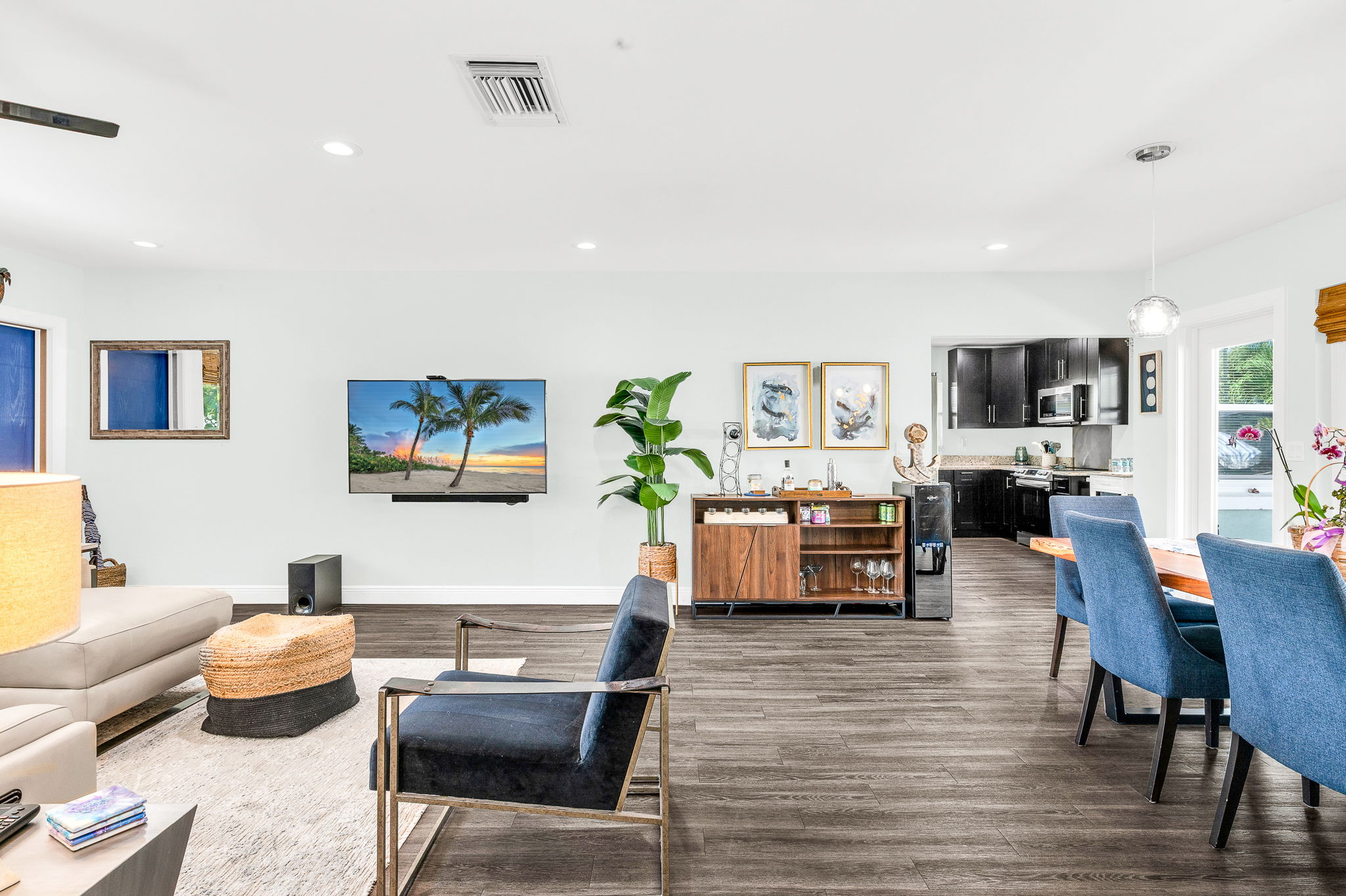 Bright, open-concept living area with modern, plush furnishings, seamlessly blending indoor comfort with outdoor living, and a relaxed coastal vibe - ideal for gathering with family and friends.  
