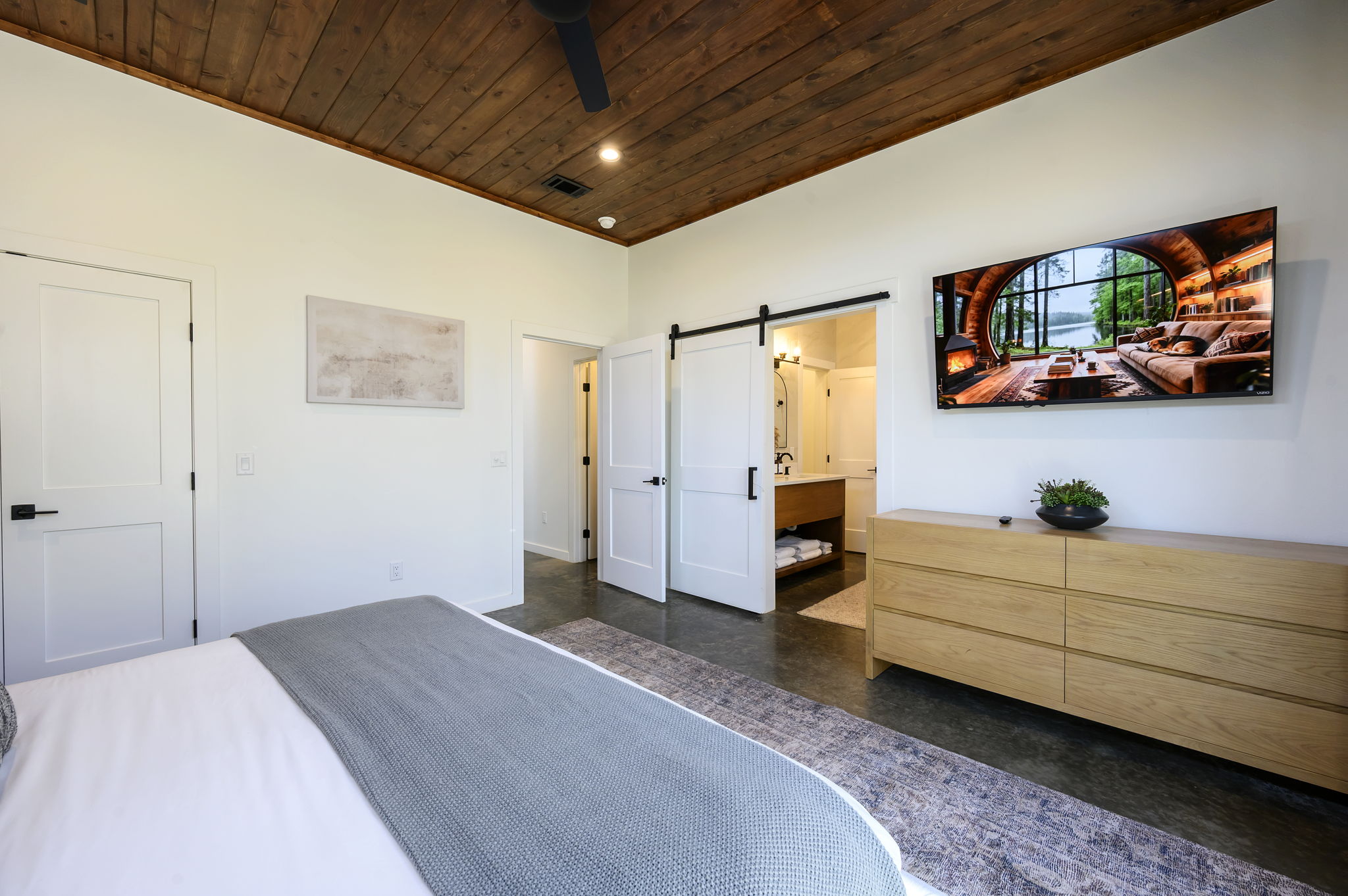 King Suite 3 - Large and spacious suite with cedar wood paneling, designer finishes, smart TV, premium king mattress, and luxury bedding. Includes stunning views of the hardwood forest. 