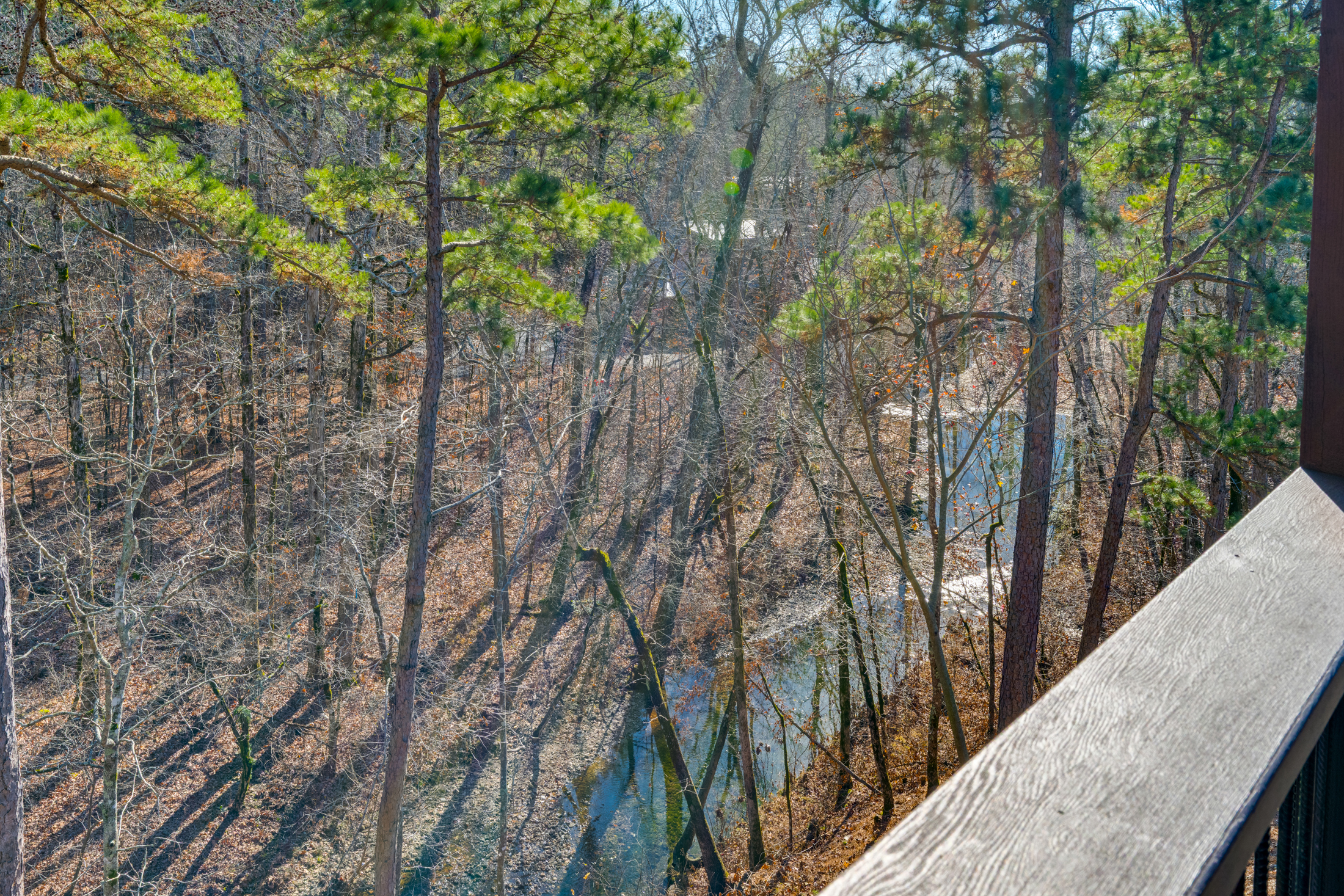 Balcony View: Breathe in nature while soaking up serene creekside vibes in Broken Bow!